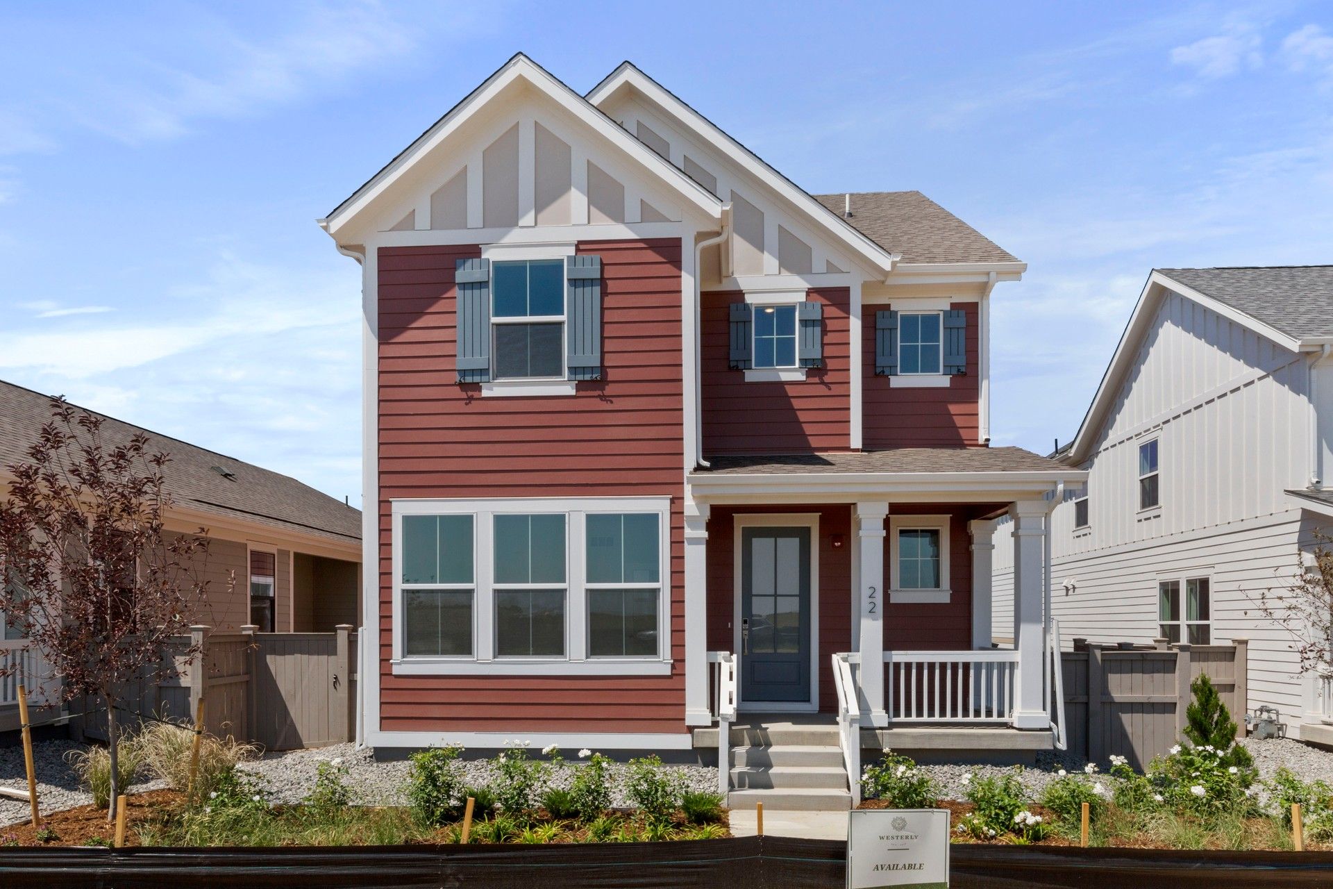 Red Gabled House in Telluride at Westerly with Porch and Garden:This Telluride home features a gabled roof, pristine white trim, and an inviting porch, set amidst lush landscaping.