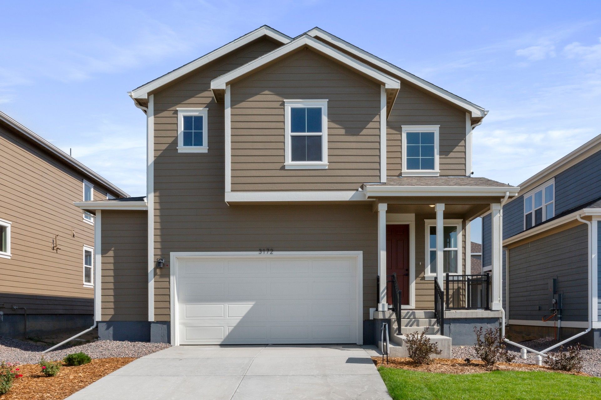 Modern Two-Story Home with Dark Taupe Siding in Lush Suburban Area:Exquisite modern design with pristine dark taupe siding and dark trim accents in lush suburban location.