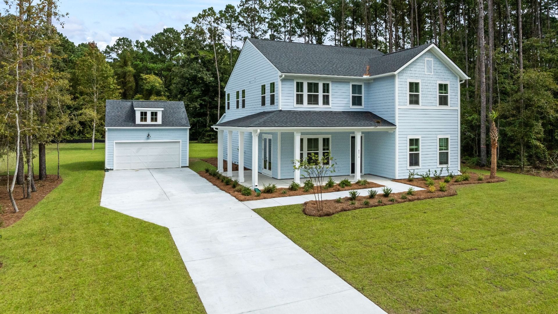 Keeneland Exterior:Keeneland Exterior at Pamlico Terrace at by DRB Homes features a wraparound porch in the front and a separated garage