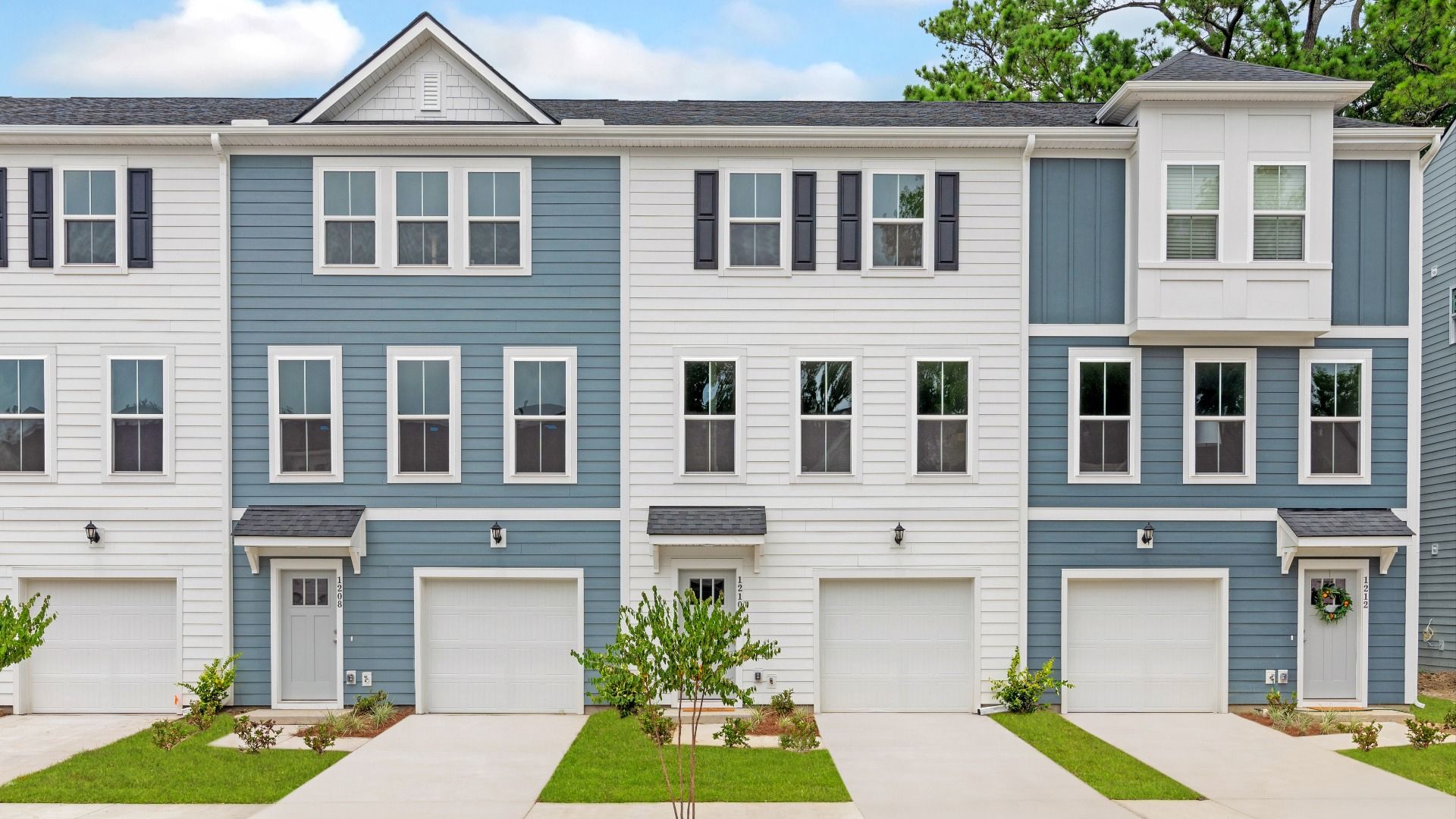 Brookgreen Plan at Circle Park Station - Front Exterior:3 level, garage townhomes with blue & white exteriors in a DRB Homes Brookgreen model home at Park Circle Station.