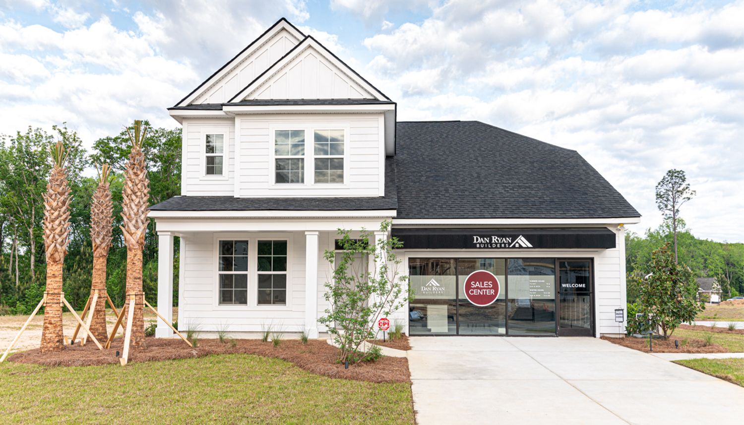 Exterior of Augusta decorated model and sales center. White house with double gable treatment.
