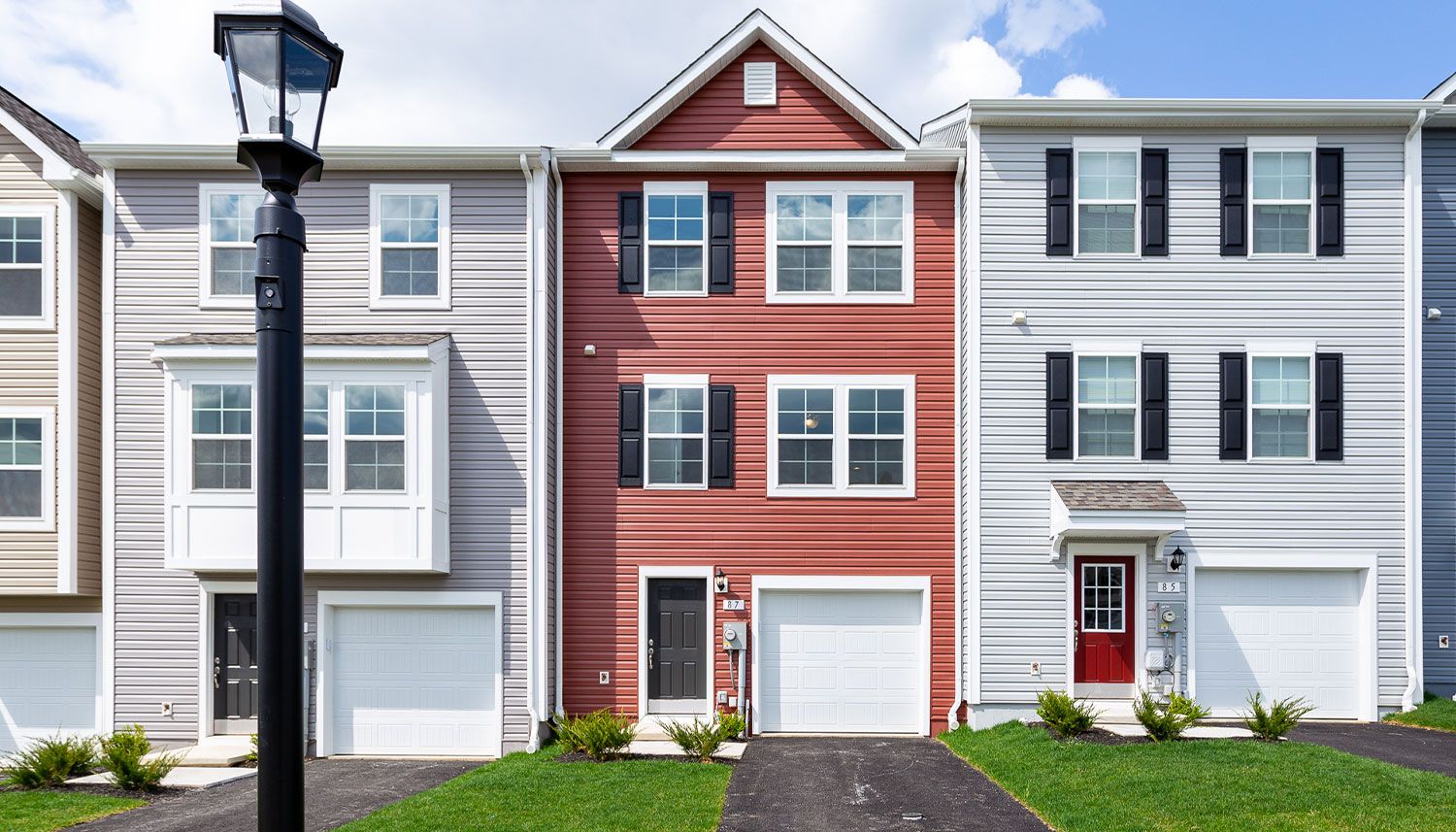 Row of 3-story, single garage townhomes, light grey and brick colored exteriors in Hagerstown, MD