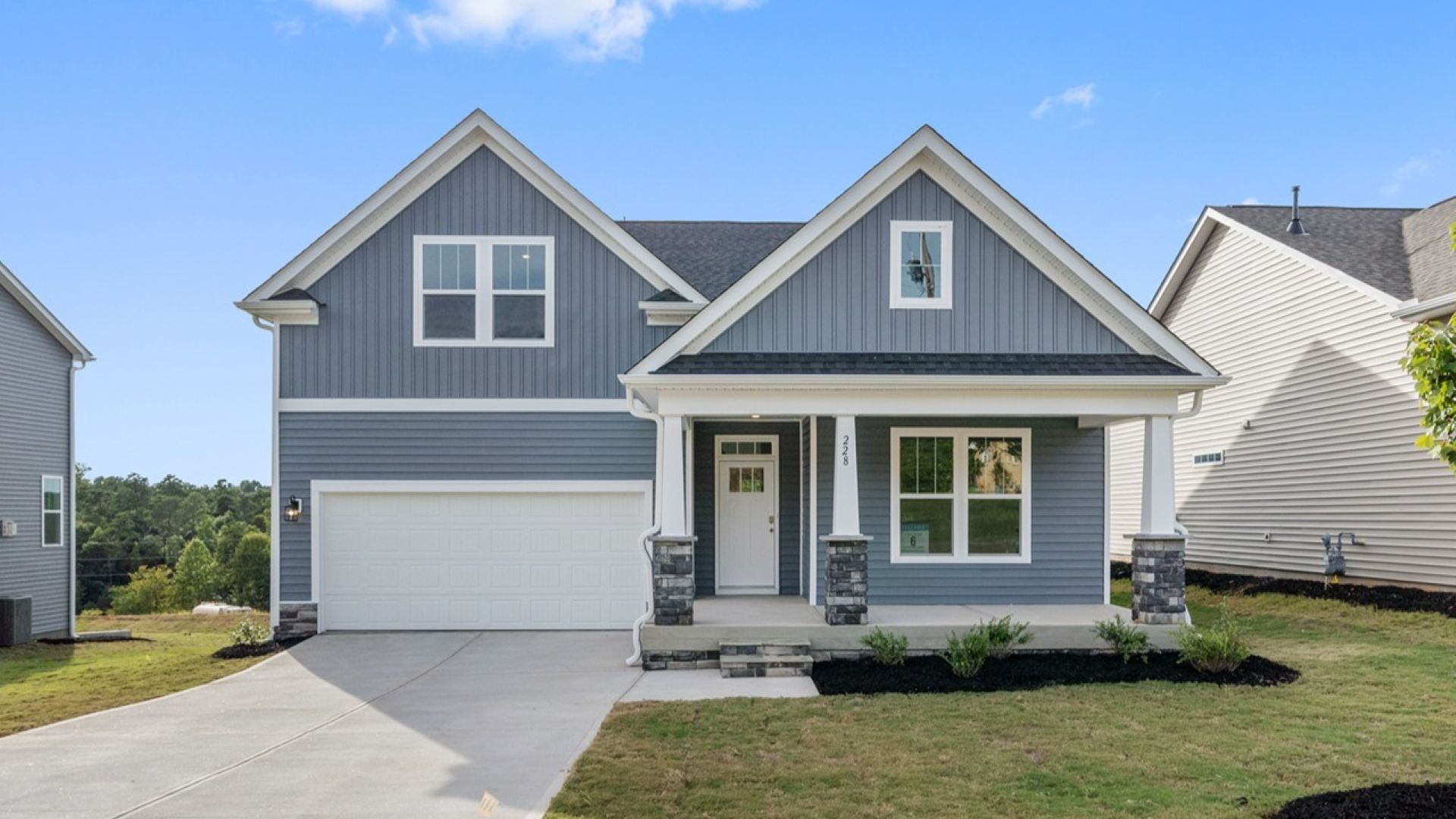 Exterior of a ranch style home in Inman, SC at Walnut Ridge by DRB Homes with stone columns