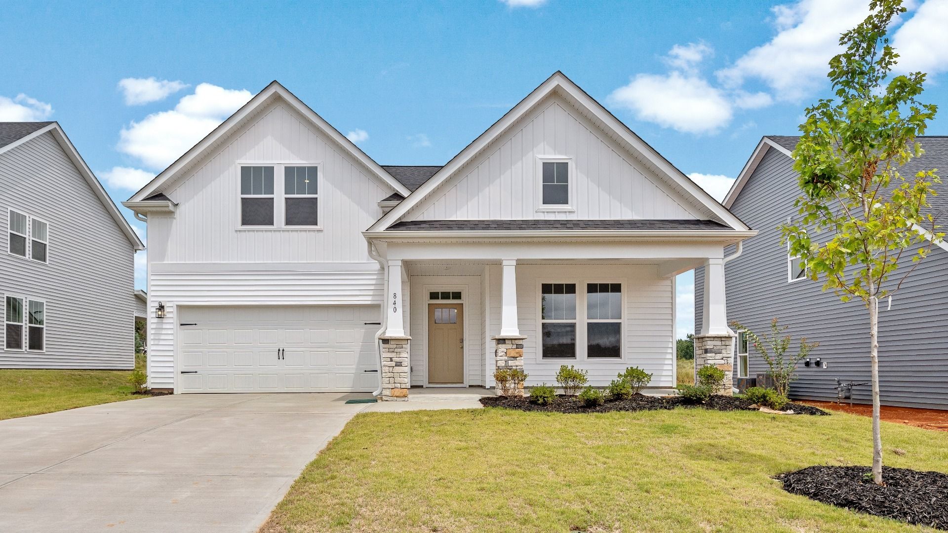 Cooper 3 floorplan with white exterior and stone detailed columns at Walnut Ridge by DRB Homes:DRB Homes' Walnut Ridge community featuring the Cooper 3 in a stunning bright white exterior with stone detailed columns