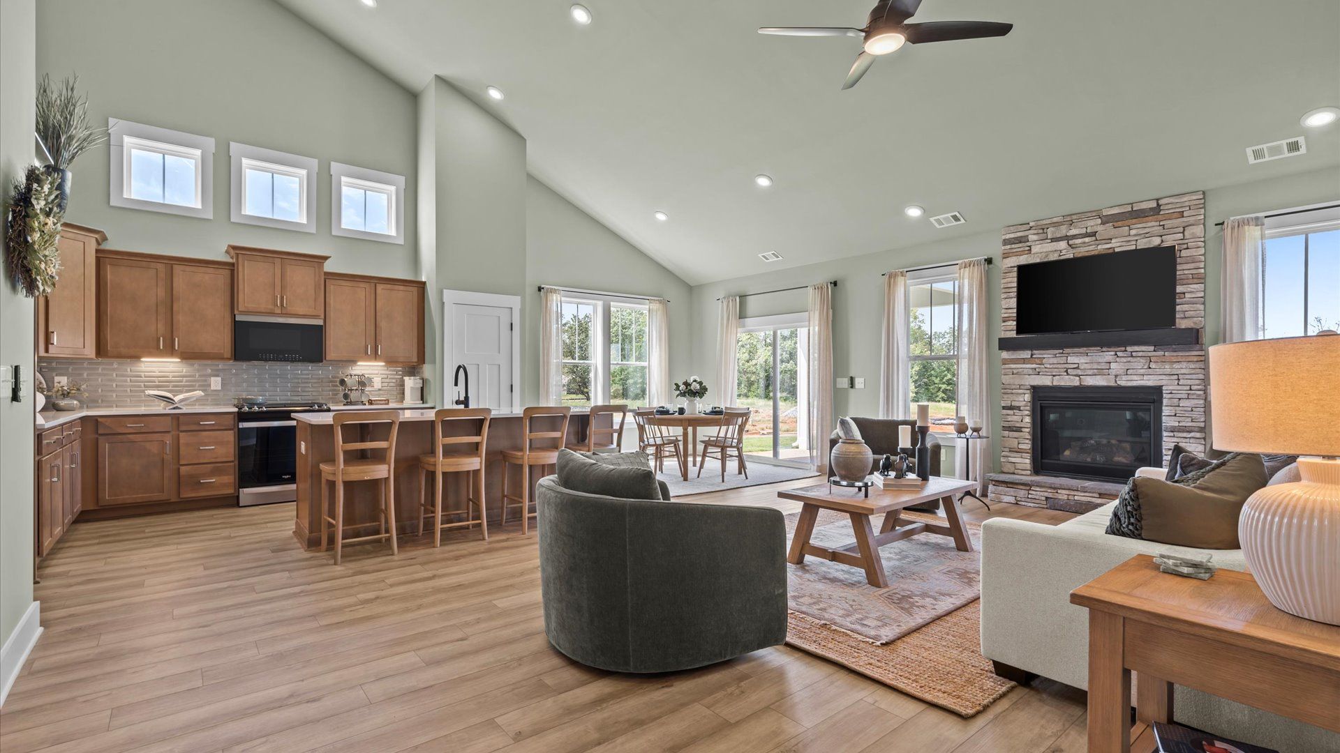 Open concept family room with hardwood flooring at Woodglen in Piedmont, SC:Spacious family room with hardwood flooring and stone fireplace at Woodglen in Piedmont, SC