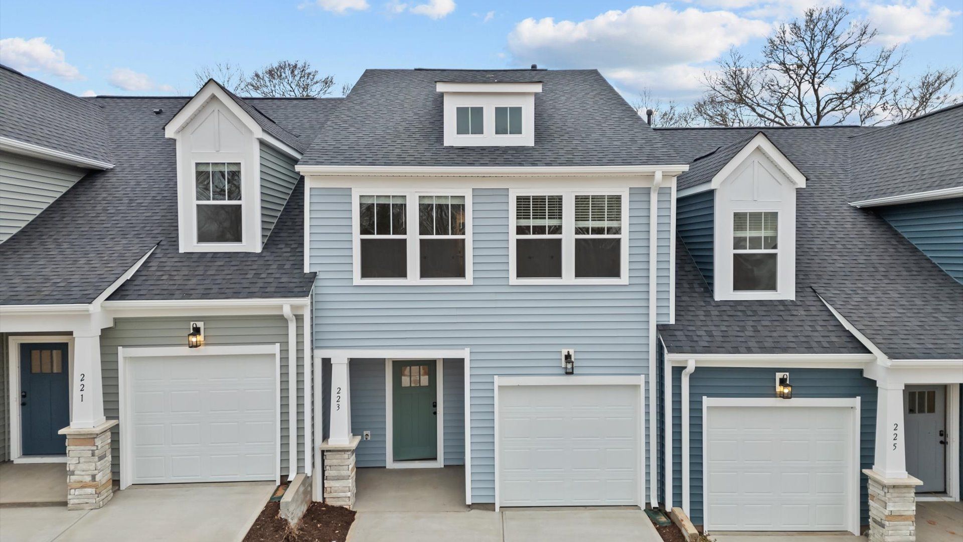 Litchfield exterior with craftsman design, light blue vinyl siding, and large windows at Aspen Ridge:Townhome with blue siding, craftsman style exterior, large widows, garage and two car parking pad in Lyman, SC at Aspen Ridge
