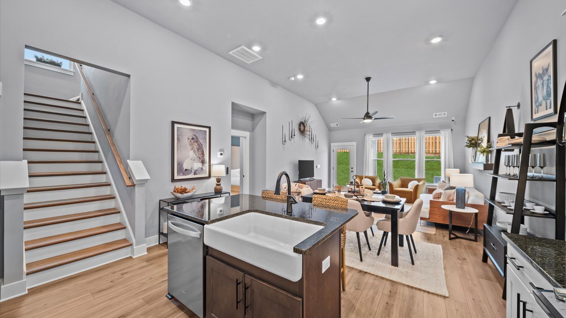Summit kitchen with farmhouse sink overlooking a spacious 2-story family room in Lyman, SC:Kitchen with large island with quartz countertops, white cabinetry, Whirpool appliances at Aspen Ridge by DRB Homes in Lyman