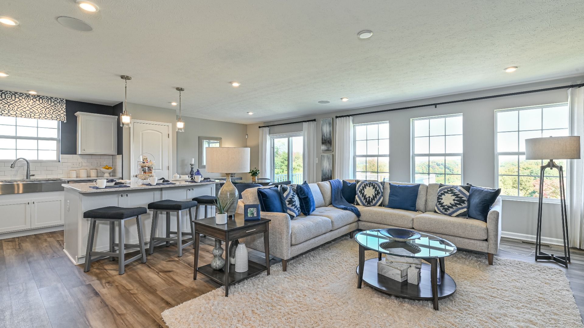 Edgewood II Model at Eastview Manor - Open Concept Main Floor:Open family room with 3 large windows along rear wall, kitchen white cabinets, large island, open dining area.