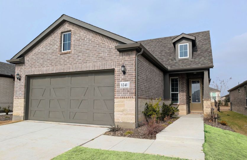 Exterior:New Construction - The Compass, a one-story home with 2-car garage