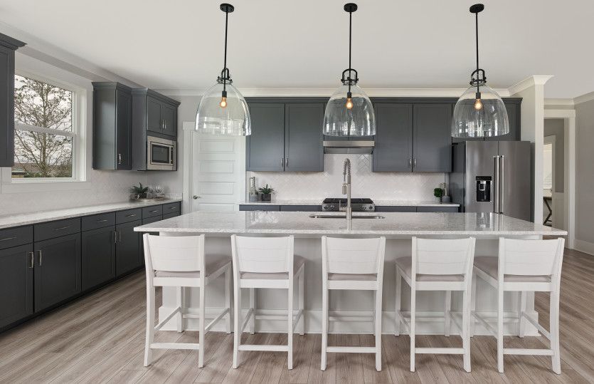 Palmary:Gourmet Kitchen with decorative lighting with grey cabinets and a bright white island.