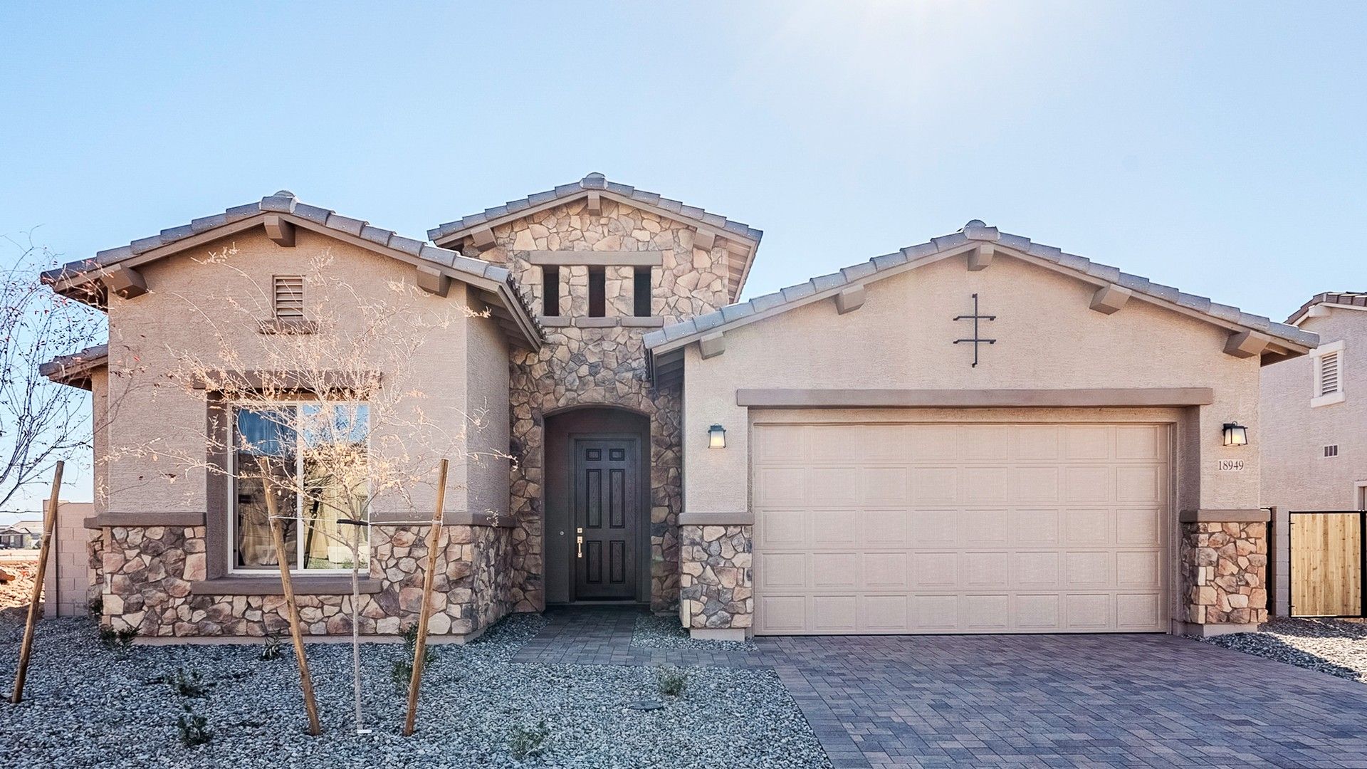 Single-Story Home with Stone Facade and Gable Roof in Windrose:Elegant stonework and arched doorway define this luxury residence in Windrose. A sophisticated architectural delight.
