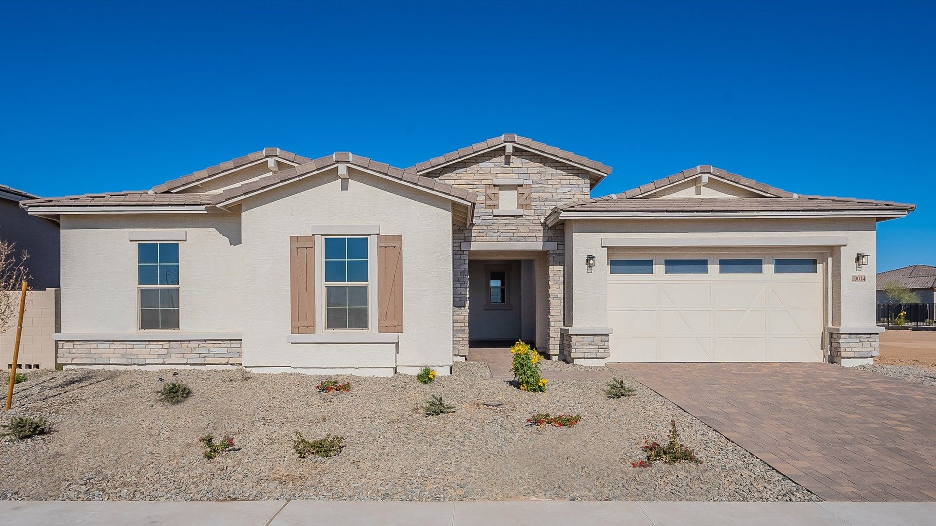 Modern Single-Story Home with Stone Accents in Granada, Windrose:Elegant stone detailing and desert landscaping enhance this Windrose home's sophisticated charm.