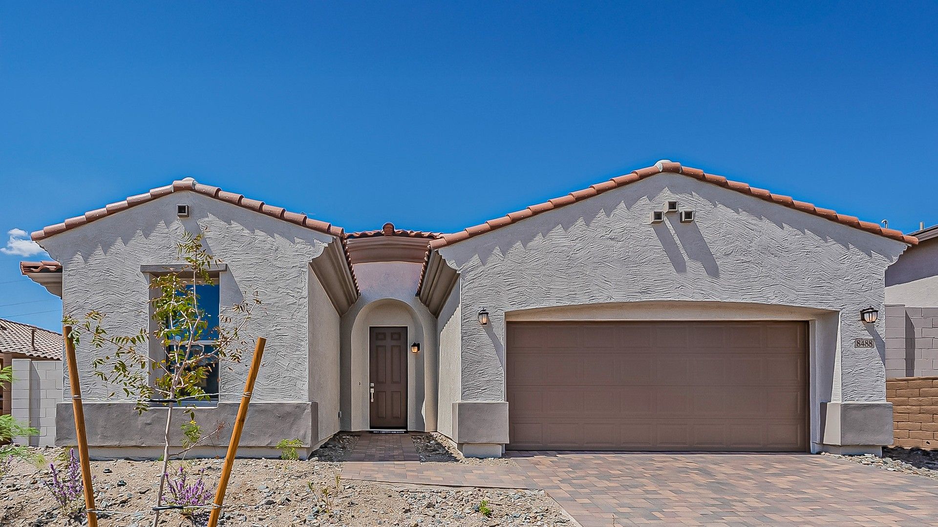 Single-family stucco home with tile roof in Hacienda at Estrella.:Elegant stucco facade and traditional tile roofing grace this Hacienda at Estrella home, exuding timeless charm.