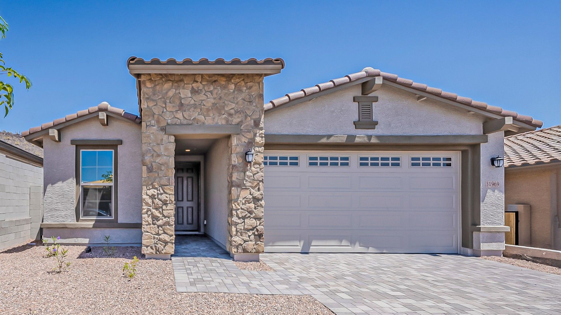 Acacia Model Home at Mystic Villas with Stone Façade in Desert Setting:The Acacia's stone façade and elegant tile roofing set apart this Mystic Villas home, offering refined desert living.