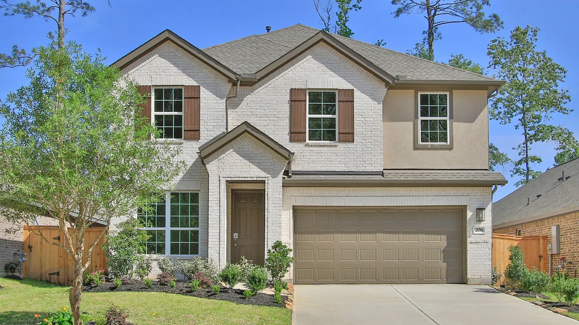 Contemporary Two-Story Home in The Woodlands Hills with Brick Façade:Elegant brick façade and charming wooden shutters enhance this luxurious Woodlands Hills residence.