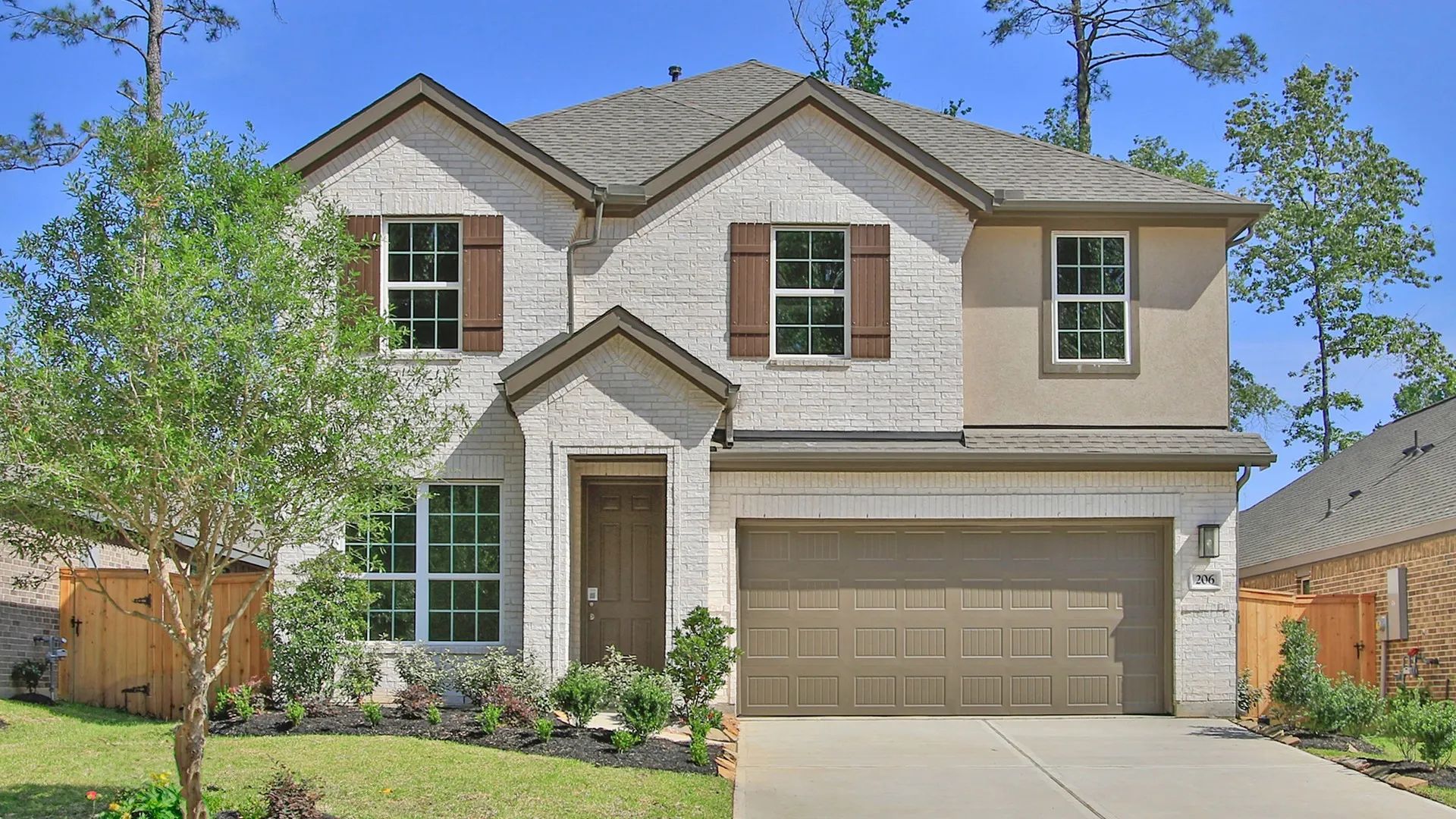 Contemporary Two-Story Home in The Woodlands Hills with Brick Façade:Elegant brick façade and charming wooden shutters enhance this luxurious Woodlands Hills residence.