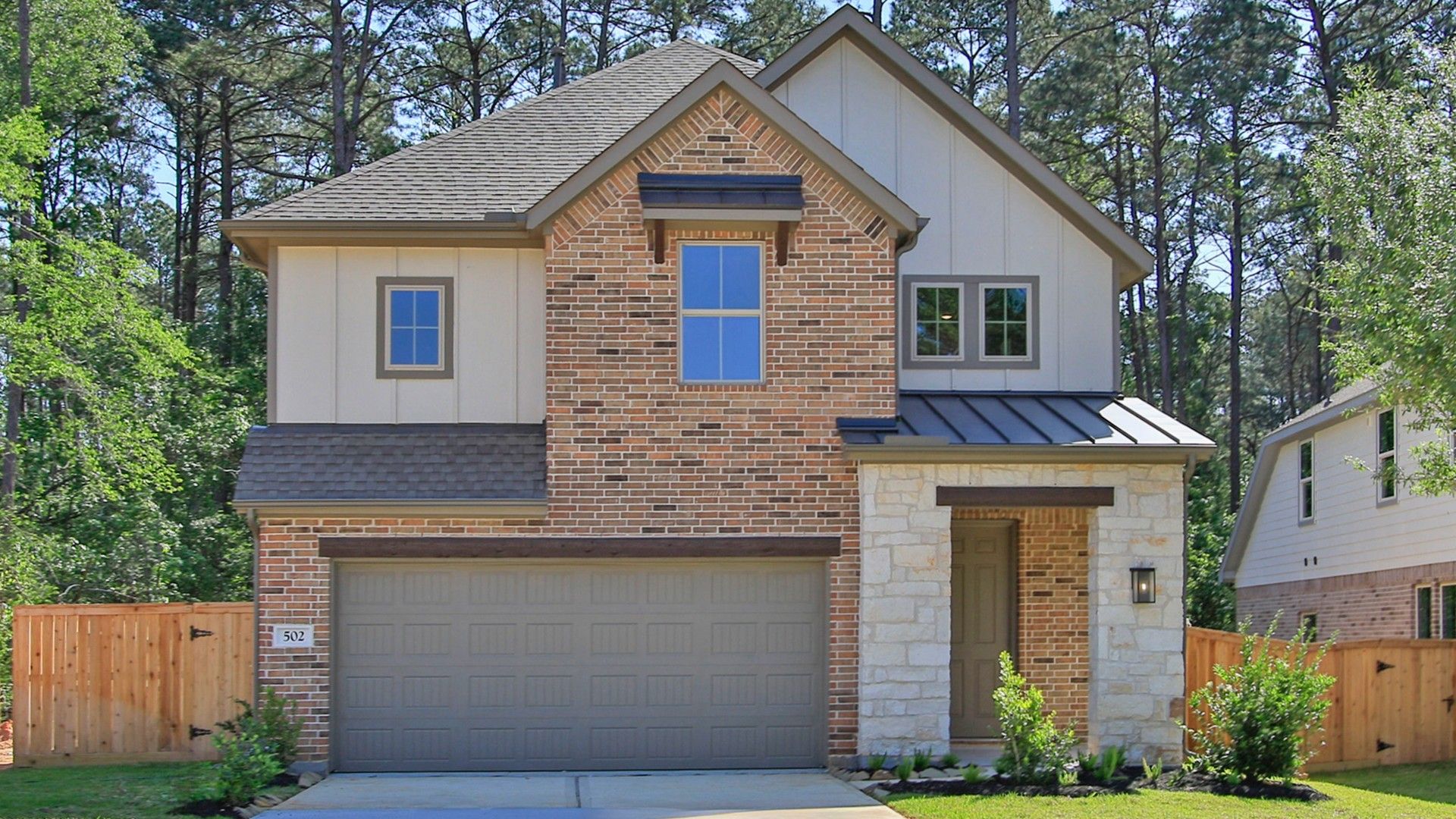 Two-Story Brick Home in The Woodlands Hills, Texas with Gabled Roof:Luxurious brick facade with elegant gabled roof, nestled in The Woodlands Hills' serene setting.