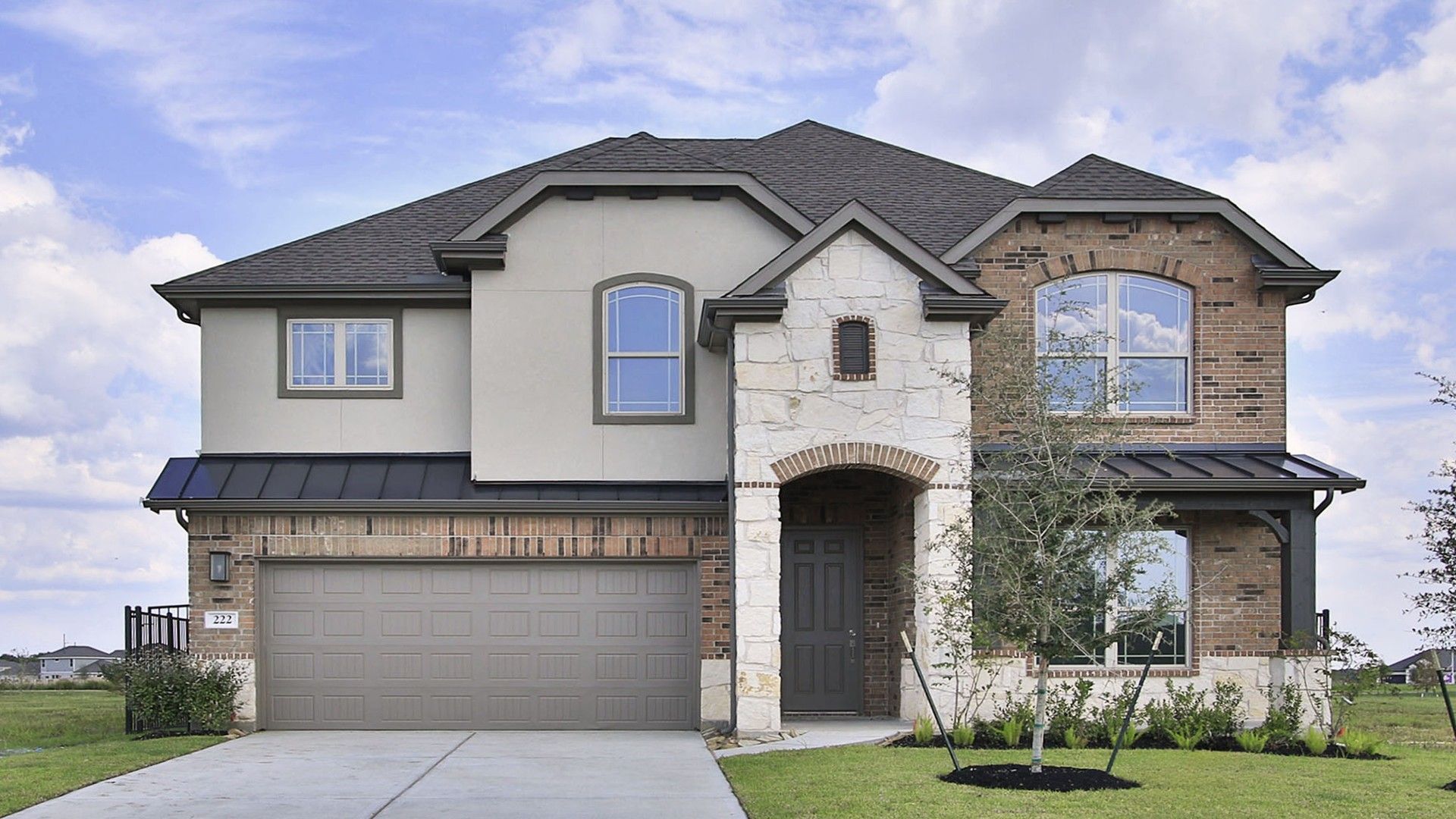 Magnolia at River Ranch Two-Story Brick and Stucco Home:Elegant stone and stucco facade with designer gabled roof, nestled in Magnolia at River Ranch, Texas.