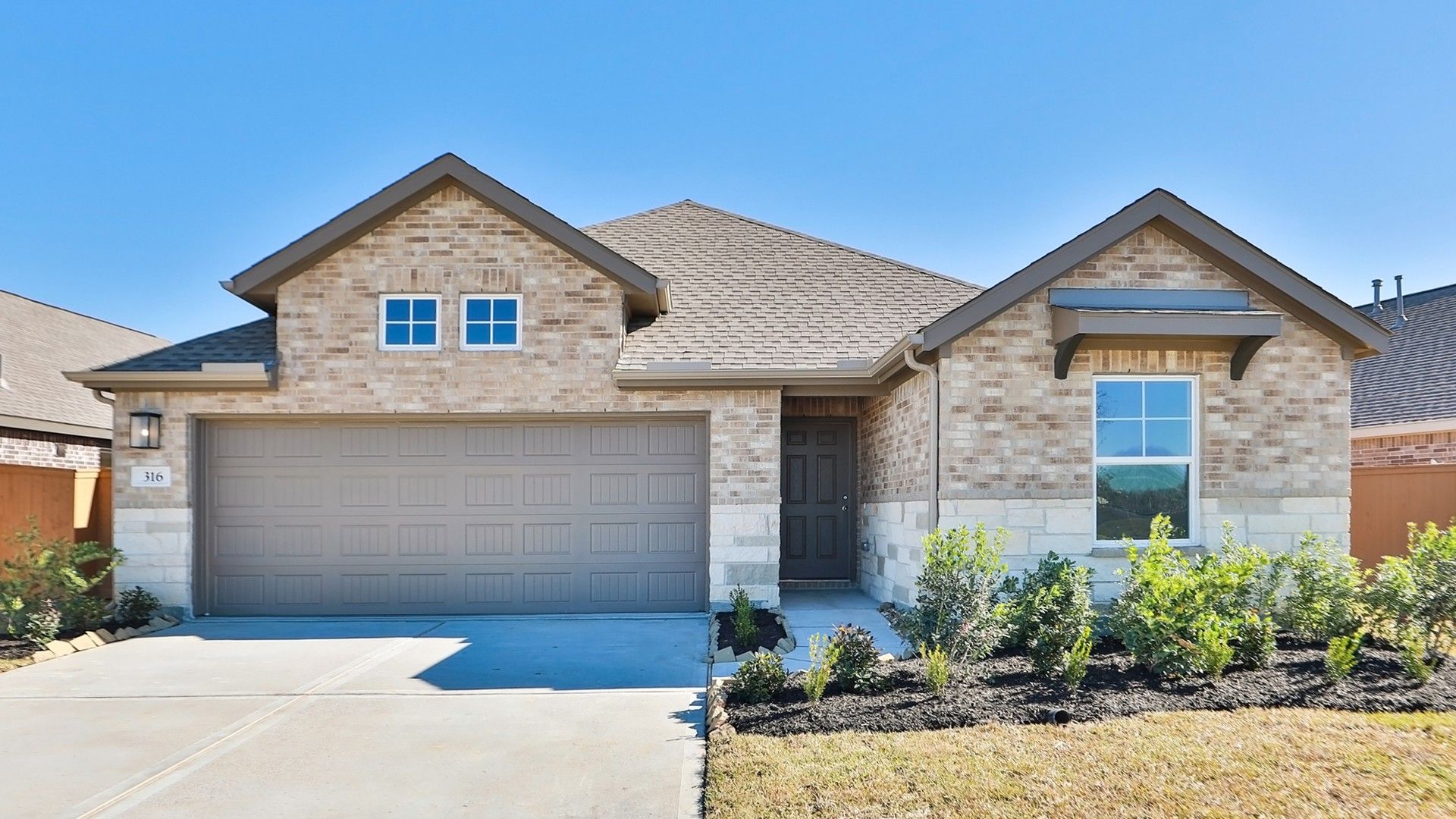 Modern Brick Home with Garage at River Ranch:Embrace timeless elegance with this brick facade, steep gable roof, and meticulous landscaping at River Ranch.
