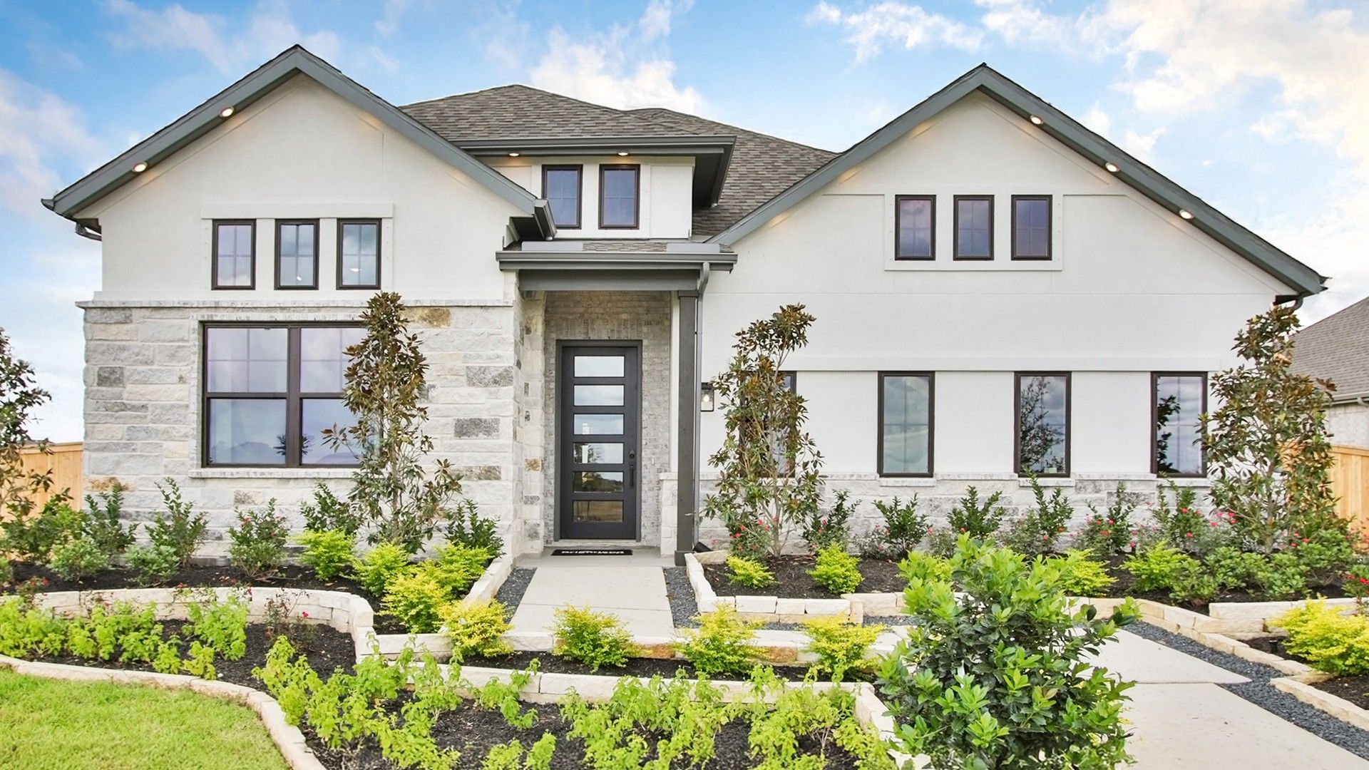 Modern White House in Coastal Point Community:Elegant white facade with stone accents and pristine landscaping in Coastal Point community.