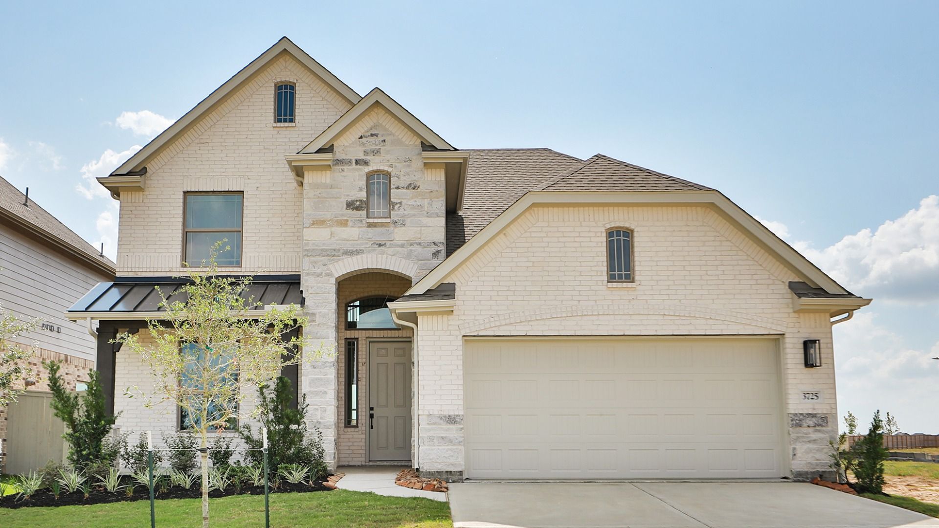 Elegant Two-Story Brick and Stone Home at Westland Ranch:Experience refined luxury in this stone-accented façade, rustic wood beams, and verdant landscaping at Westland Ranch.