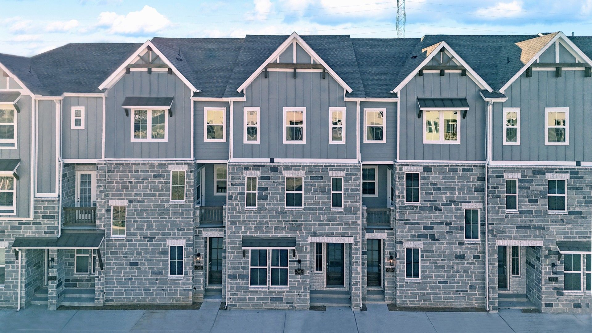 Elegant Townhomes with Gray Stone Facades at Collin Creek:Discover refined elegance with stone facades and gabled roofs at Collin Creek. Experience luxury living.
