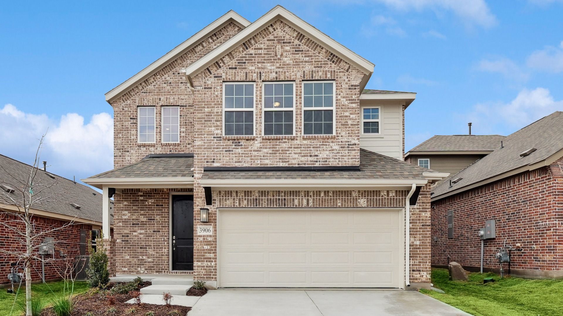 Two-Story Brick Home in Meridian at Bel Air Village:Distinctive brick facade with large, elegant windows and gabled roof in the heart of Meridian at Bel Air Village.