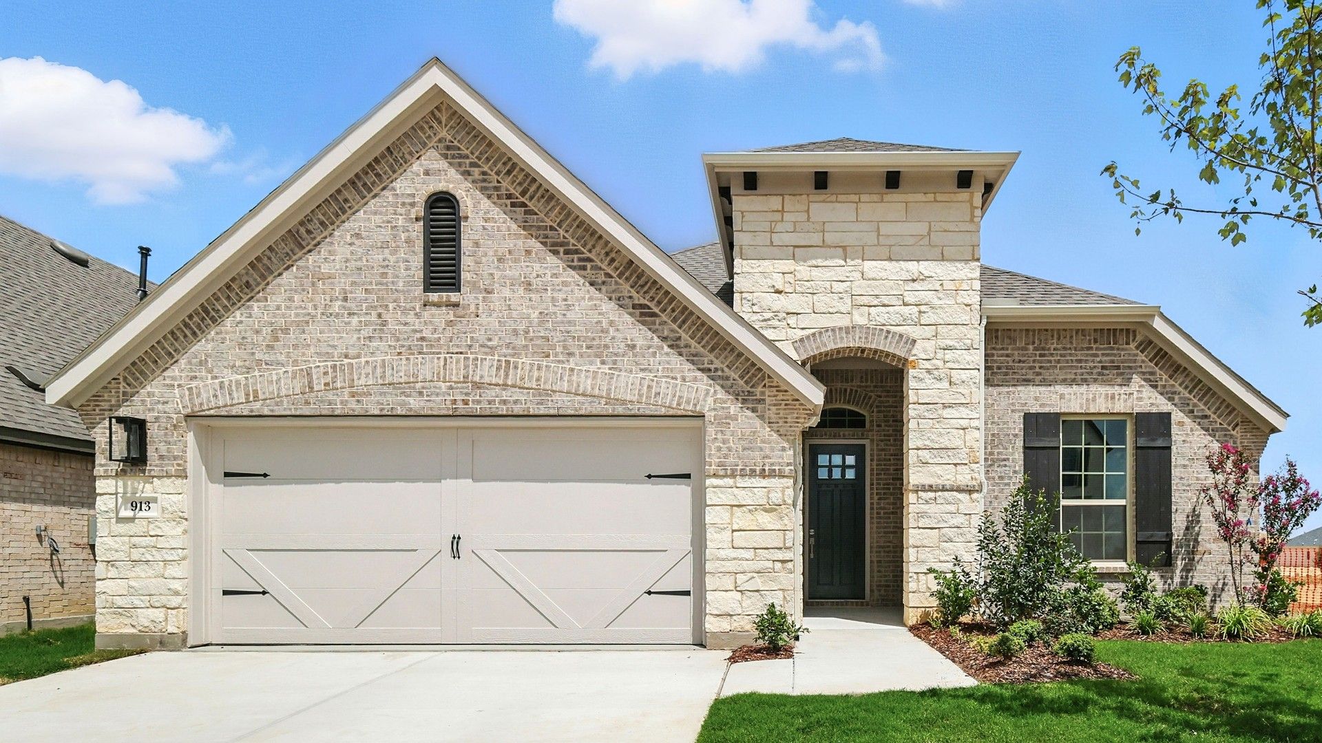 Single-family home at 913 Schuberts Road in Wildflower Ranch community:Stately brick and stone exterior with lush landscaping in Wildflower Ranch, 913 Schuberts Road.