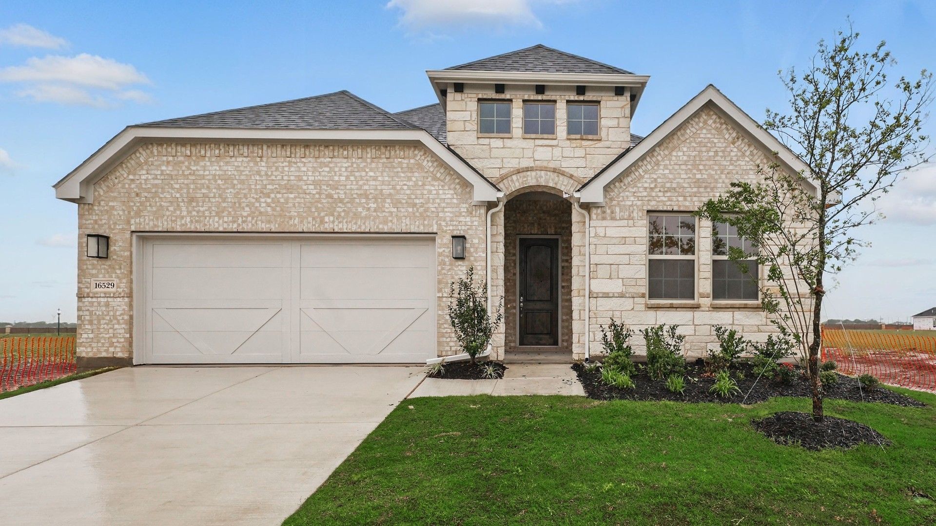Green Meadows Juniper Plan Home at 16529 Freshwater Drive:Luxurious brick exterior with arched entryway in Green Meadows' Juniper plan.
