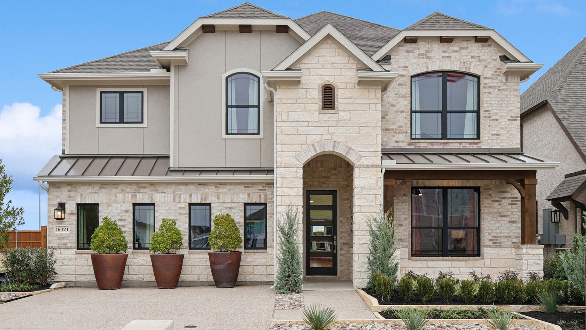 Two-Story Stone and Brick Home at Wildflower Ranch:Elegant stone facade with arch entry and manicured landscaping at Wildflower Ranch.