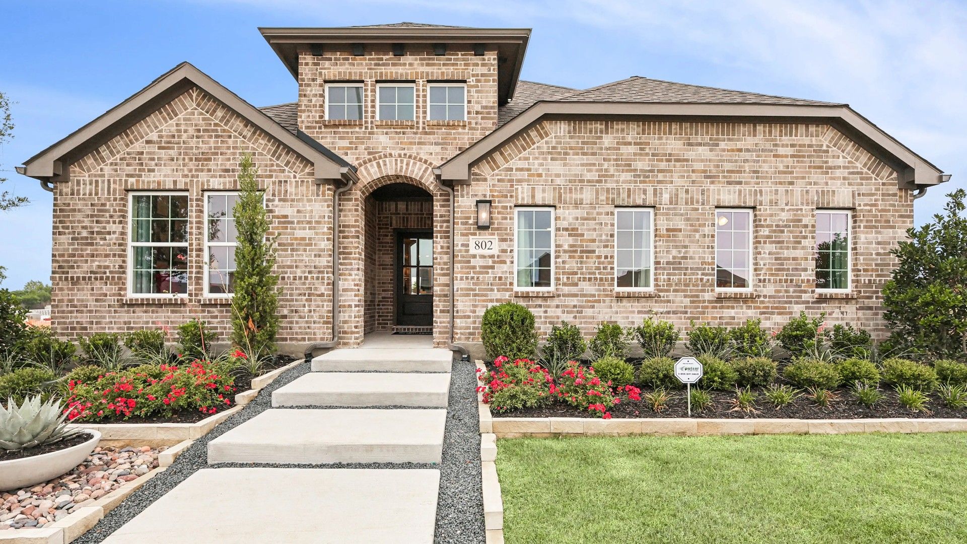 Modern Brick Home in Simpson Crossing with Arched Entryway:Stunning brick facade with elegant arched entryway and lush gardens at Simpson Crossing.