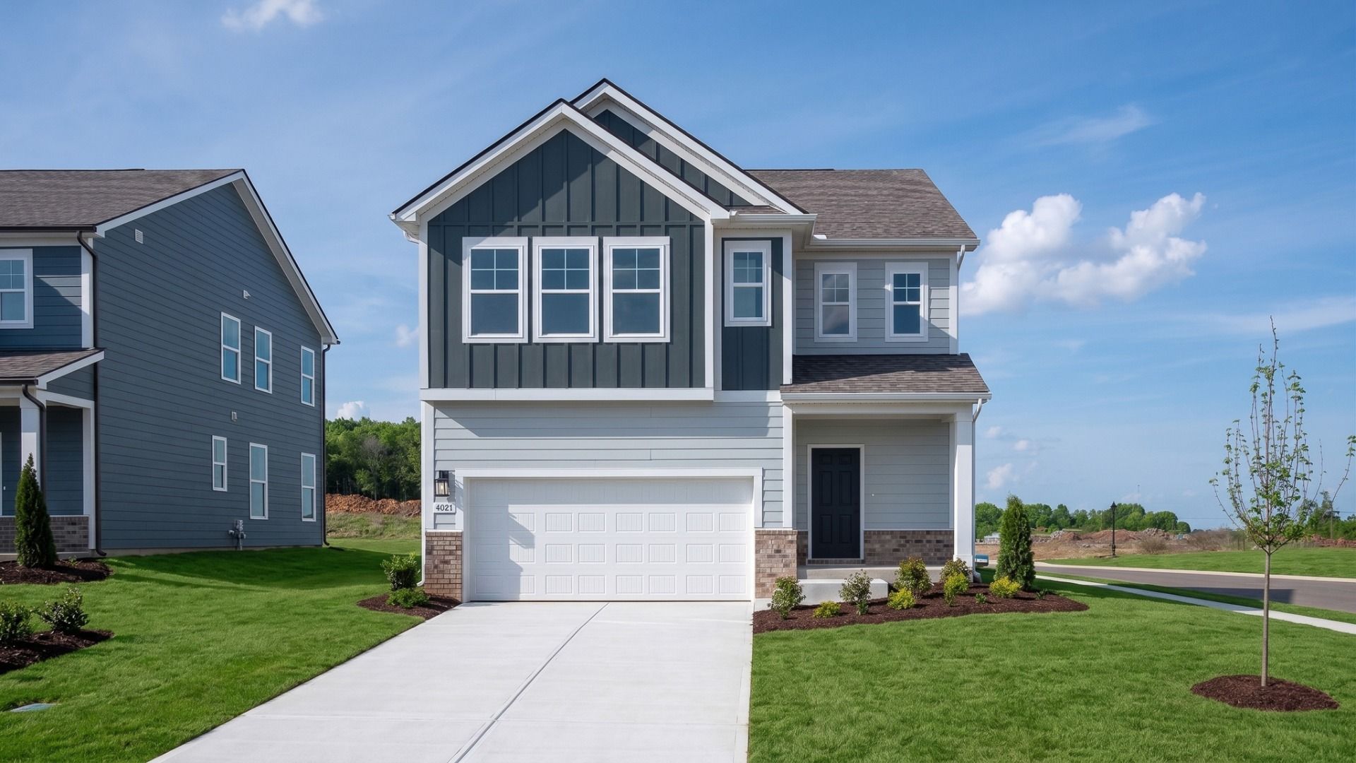 Neroli Plan Exterior:Exterior of Neroli plan home built in Smyrna, TN with two-tone blue Hardie siding and brick accent