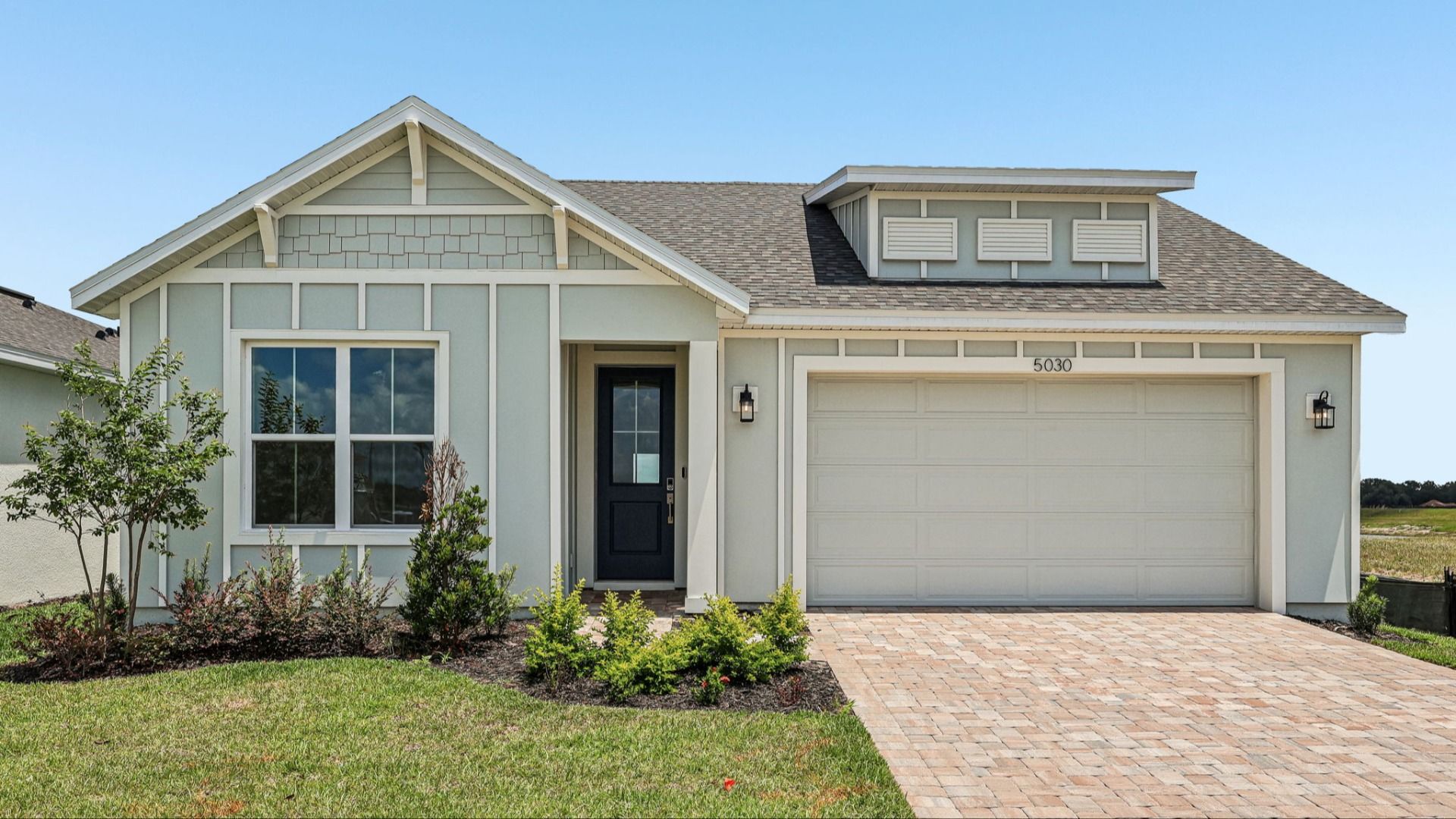 Longleaf Exterior:Longleaf Floor Plan Exterior with Paver Driveway and Walkway New Homes in St. Cloud at Lakeside at Satilla