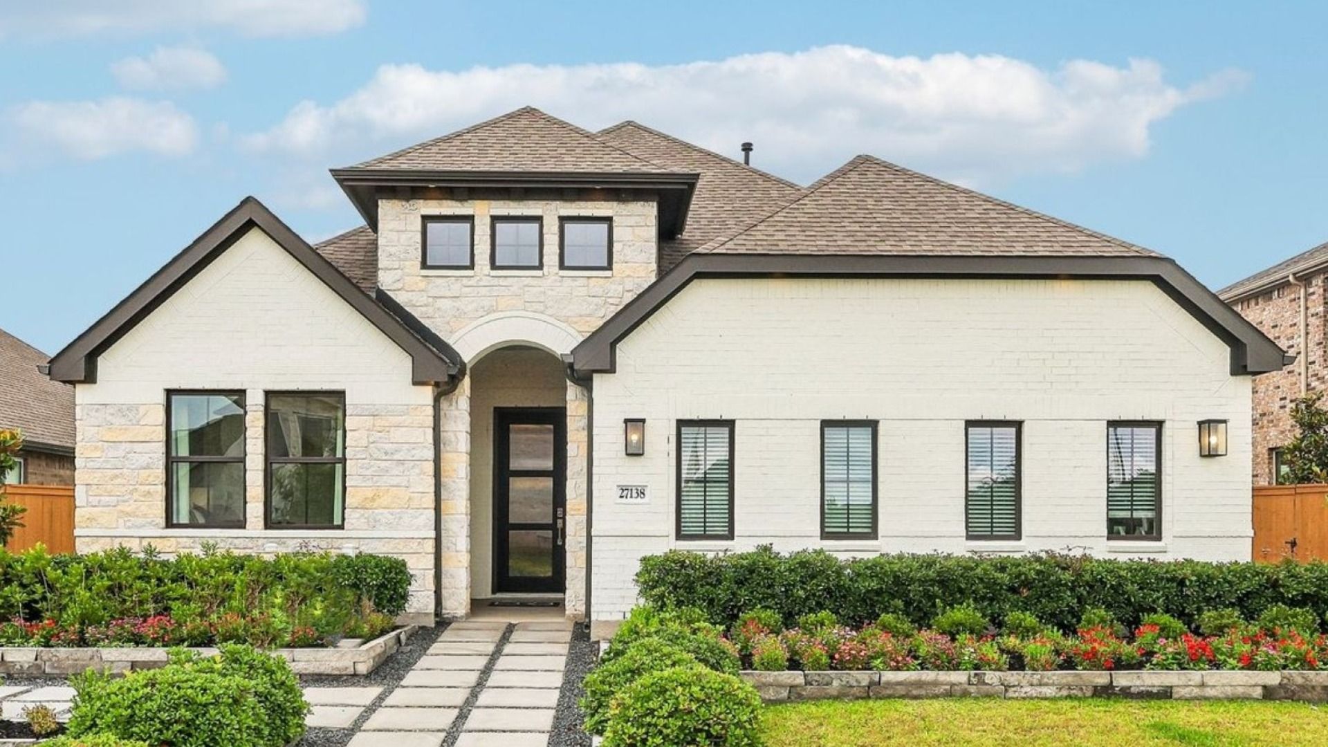 Modern White Brick Home in Sunterra Community:Experience elegance with this Sunterra home, featuring a pristine white brick facade and lush, manicured landscaping.