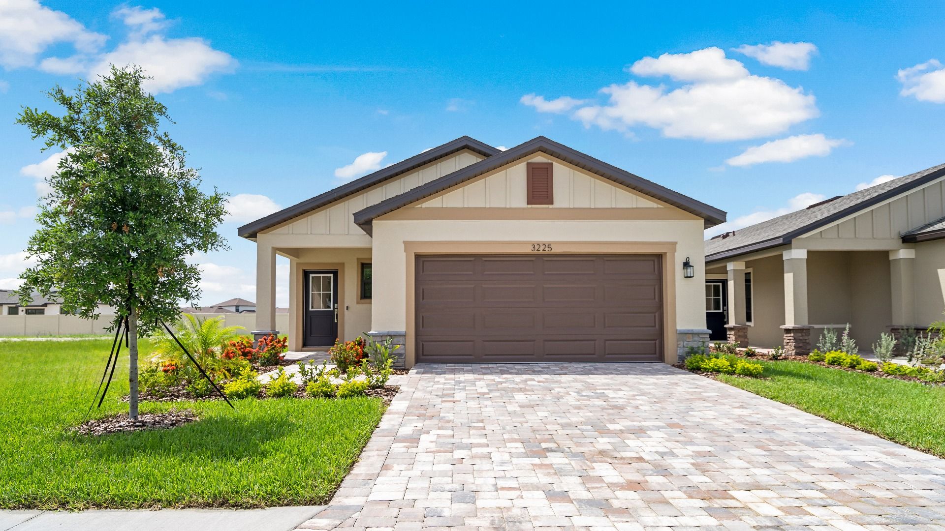 The Atlantic at Grasslands West – Farmhouse Elevation:New single-story home in Lakeland, FL The Atlantic by DRB Homes at Grasslands West with 2-car garage and open-concept design.