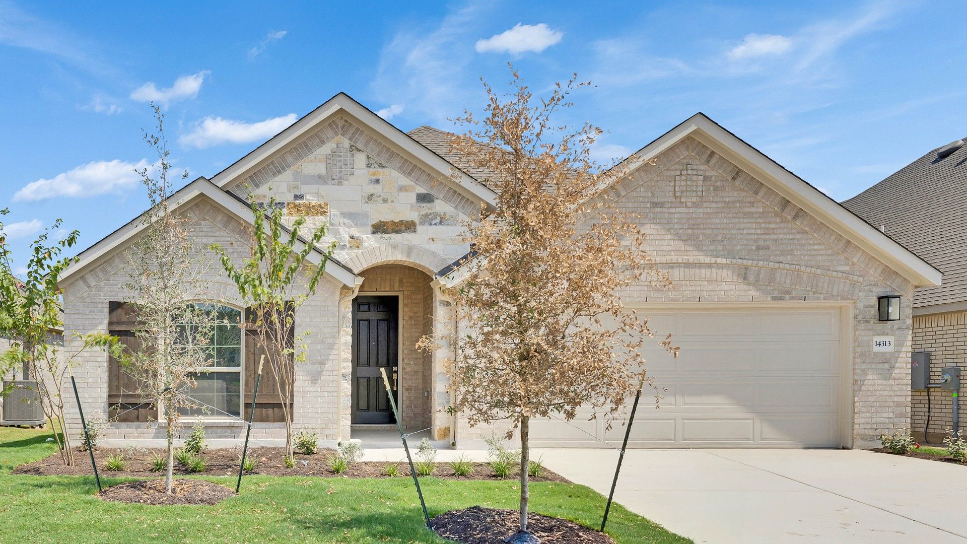 Elegant Brick House with Arched Entry in Carillon:Timeless brick and stone facade with arched details and stylish wooden shutters in Carillon area. Elegant landscaping.