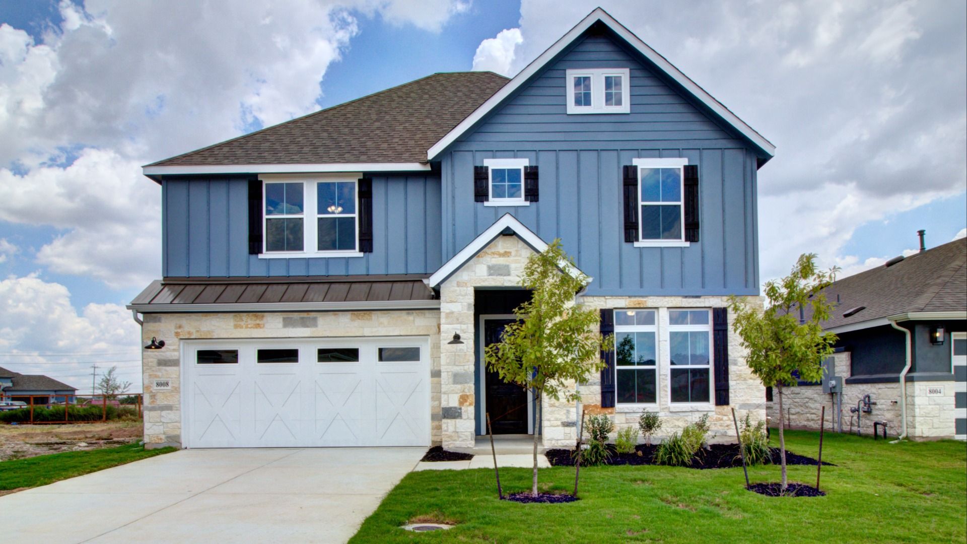 Magnolia House Exterior in The Crossvine Neighborhood:Elegant blue painted siding and stone façade merge seamlessly in this luxurious Crossvine residence.