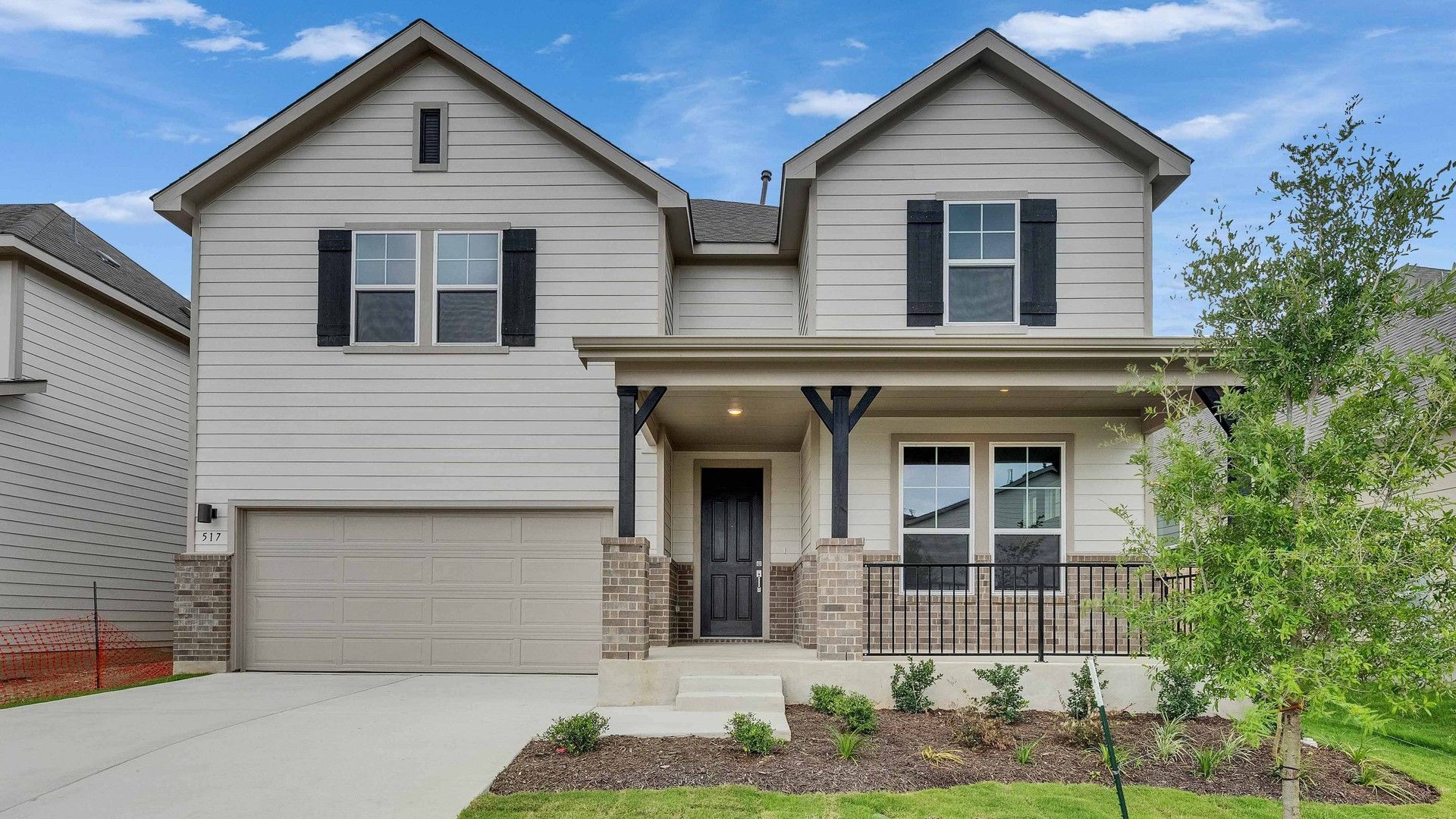 Two-Story Modern Home with Porch and Brick Accents in Magnolia, Spring Creek:Elegant two-story home features brick accents, charming porch, and manicured lawn in Magnolia, Spring Creek.