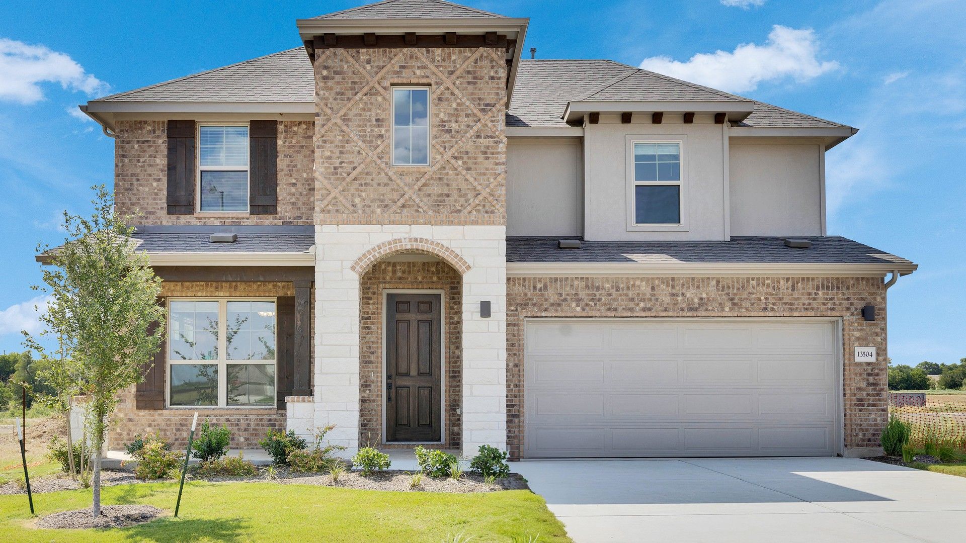 Elevation O:Luxurious brick facade with exquisite wood shutters in Rosewood at Briarwood. Beautifully landscaped gardens.