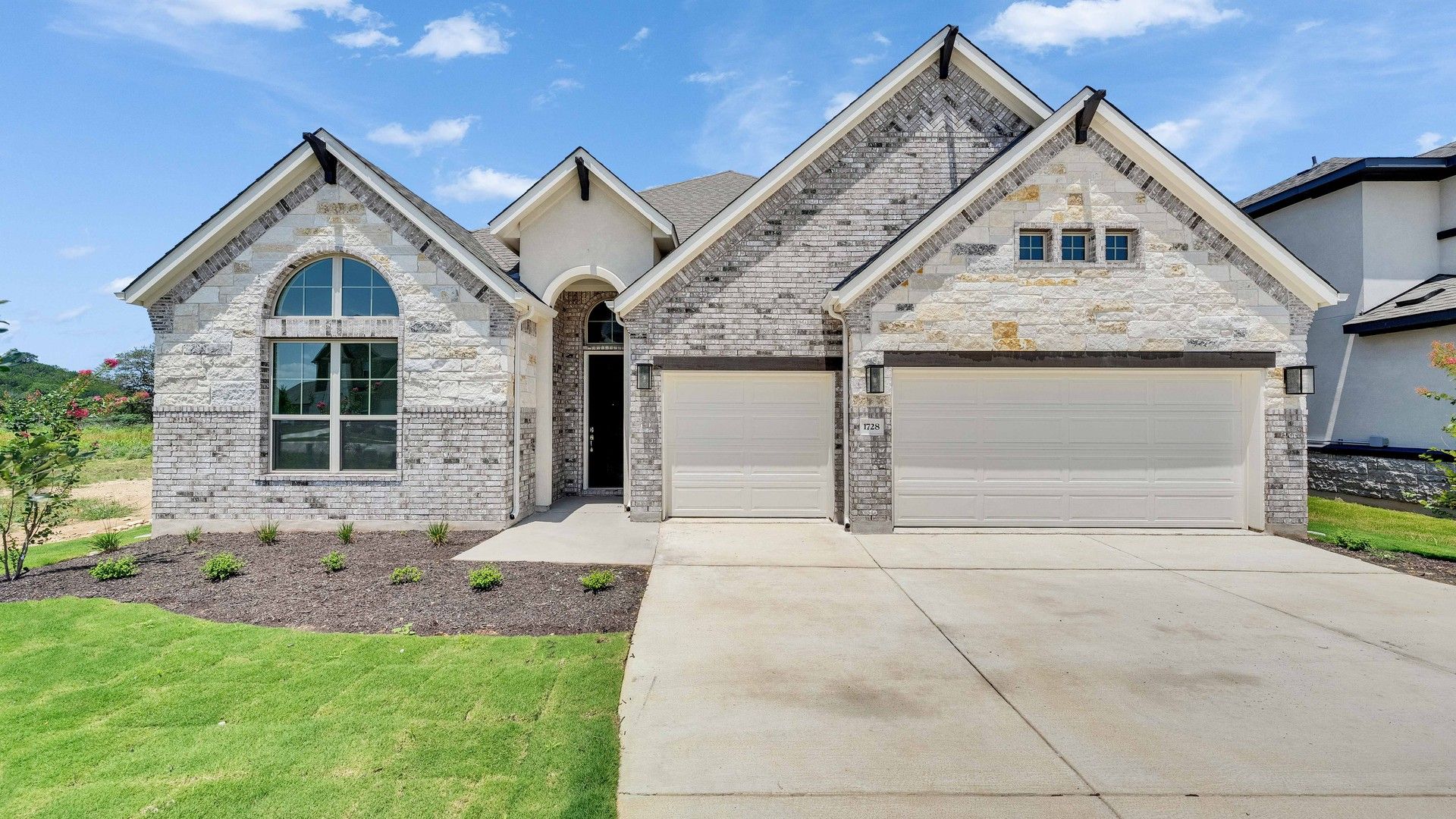 Luxurious Stone House in Retreat at San Gabriel, Texas:Exquisite stonework and an arched window highlight this luxury home in Retreat at San Gabriel, Texas.