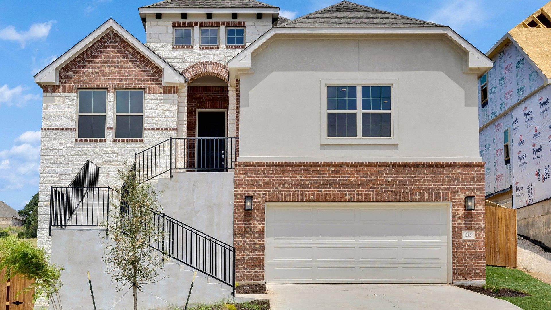 Elevation O:Experience elegance with stone facade, arched entry, and lush landscaping in San Gabriel’s luxurious neighborhood.