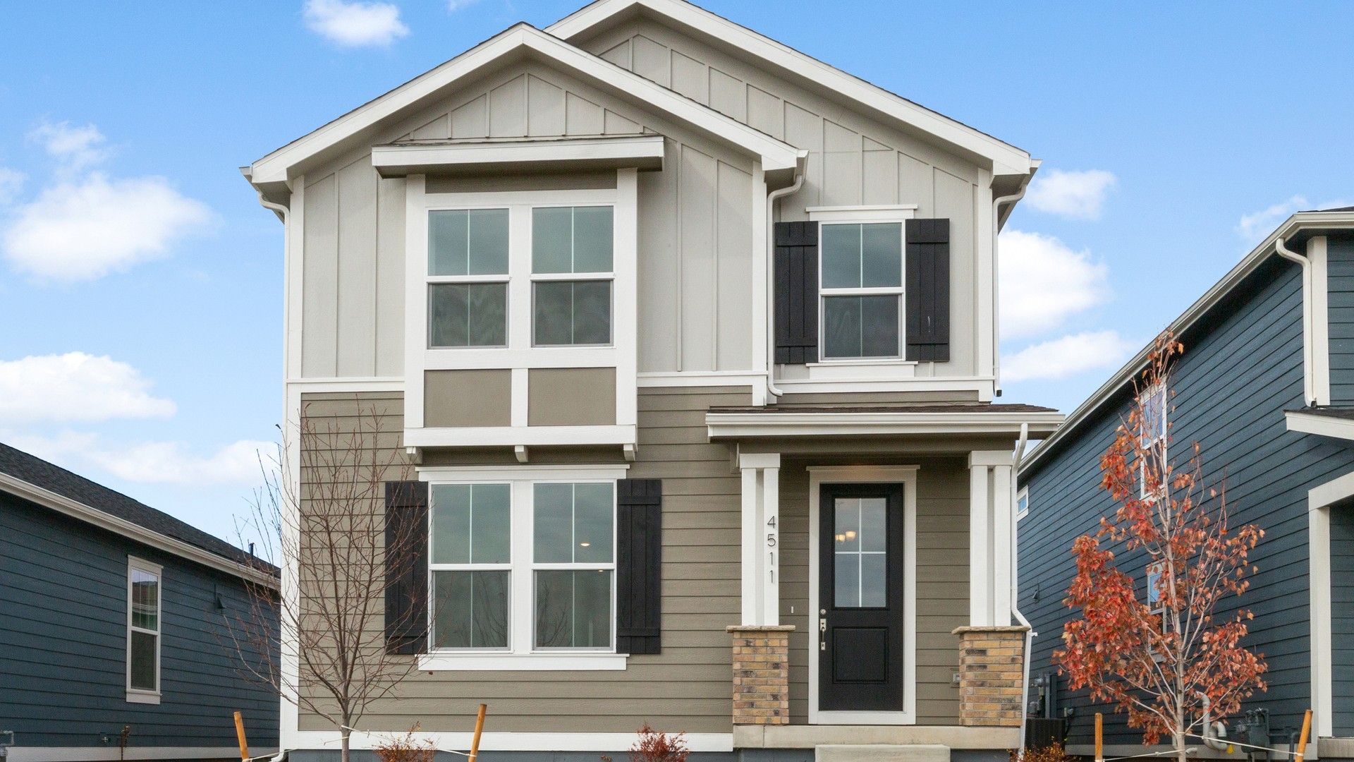 Modern Two-Story Home at Timnath Lakes with Gray Siding and Black Shutters:Timnath Lakes gem featuring striking gray siding, elegant black shutters, and expansive windows, exuding refined sophistication.