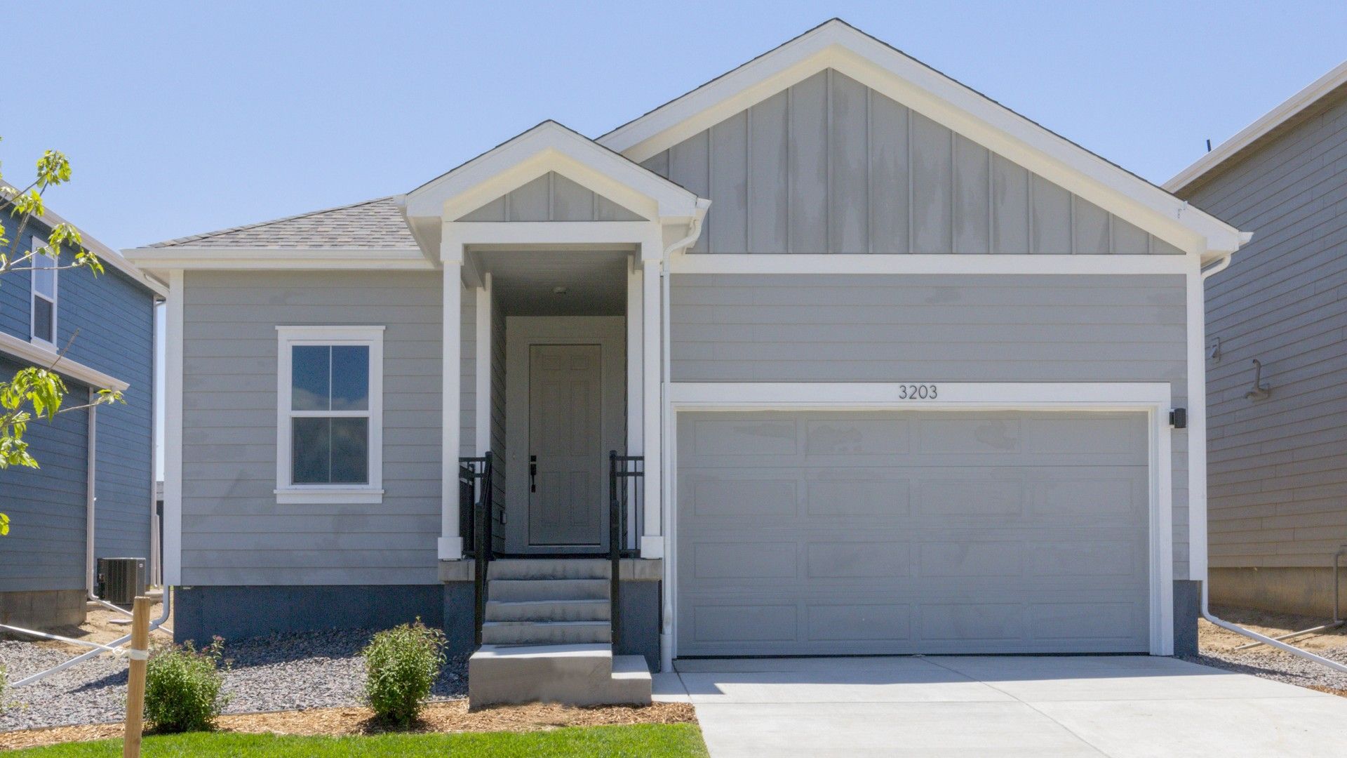Modern Grey Bungalow in Honeysuckle at Bloom Community:This elegant suburban bungalow boasts a refined gable roof and charming front porch. Located in Honeysuckle at Bloom.
