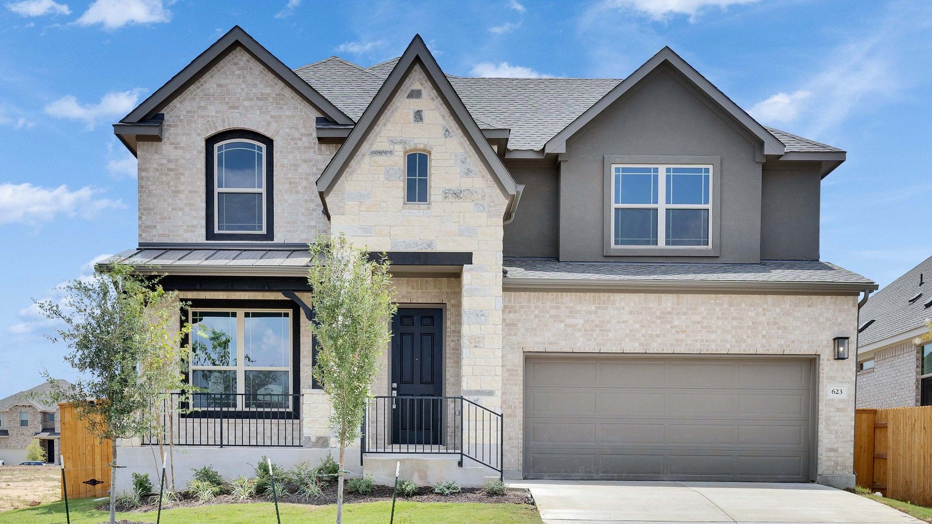 Oaks at San Gabriel two-story home in Georgetown, Texas:Luxurious stone facade with wood accents defines this elegant Georgetown residence at Oaks at San Gabriel.