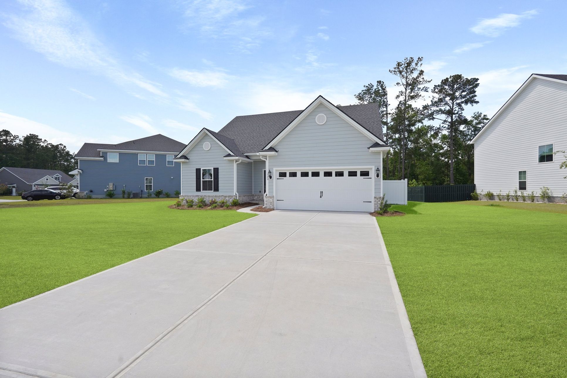 Front exterior view of the Harbor II floor plan by Ernest Homes, a two-story gray siding house wi...:Harbor II – Exterior Angled View | Ernest Homes