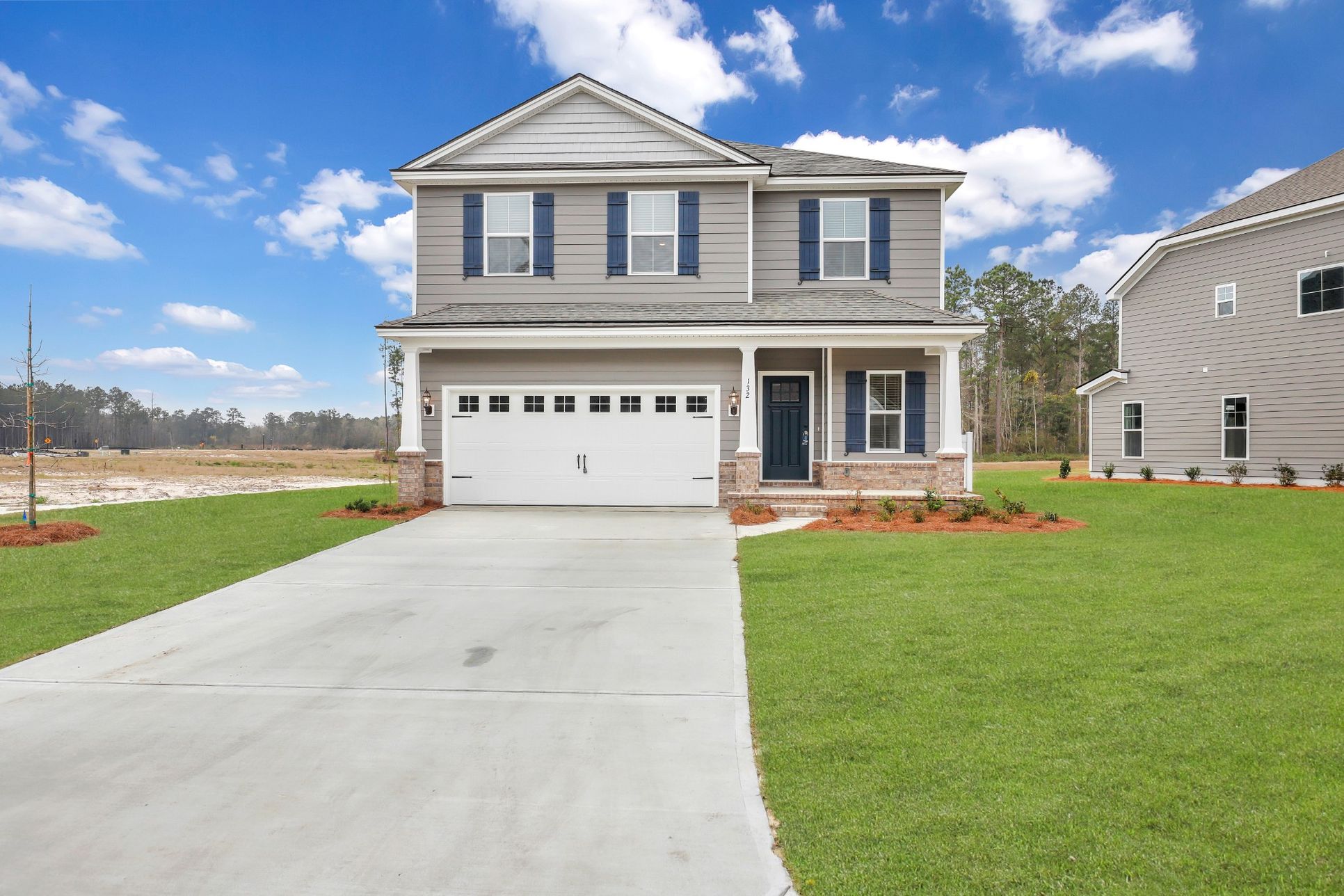 Seabrook C with 4 side brick water table with carriage style garage doors built by Ernest Homes B...:Seabrook C - Front Elevation with Raised Foundation | Ernest Homes