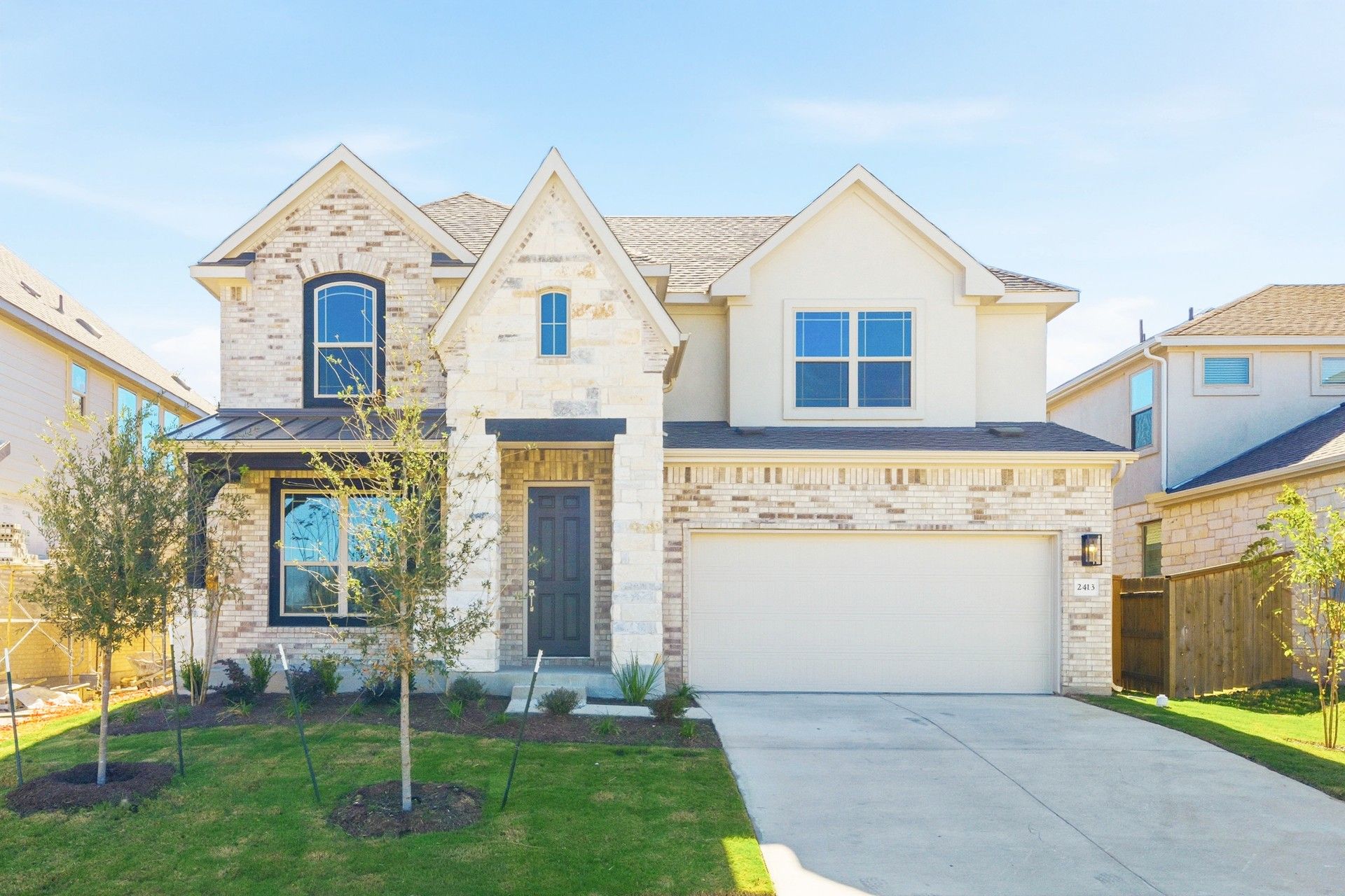 Elegant Brick Home at Oaks at San Gabriel with Stone Accents:Luxurious stone facade, intricate brickwork, and vibrant landscaping define this Oaks at San Gabriel residence.