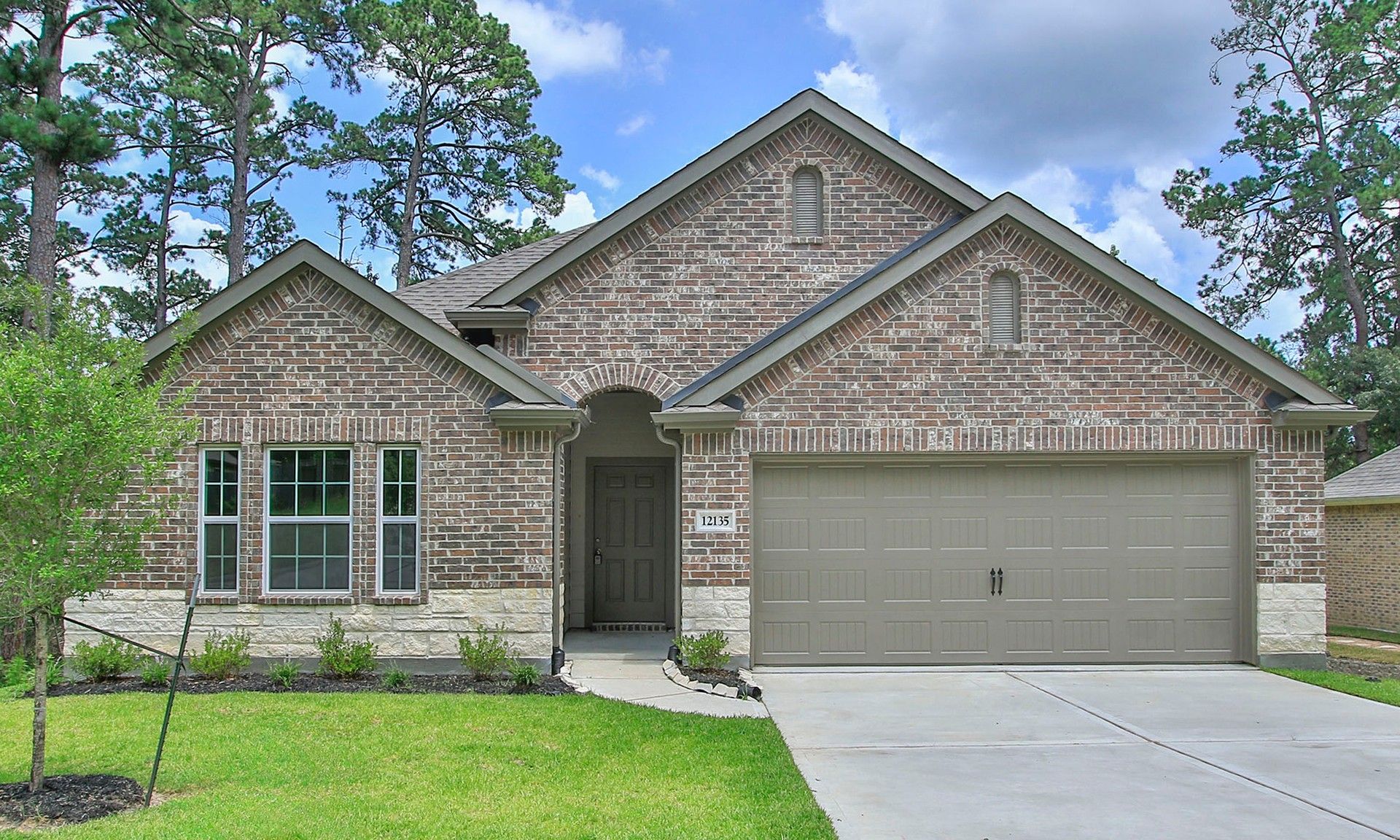 Luxurious Brick Home with Garage in Texas National Forest Area:Stunning brick facade, gabled roof, and lush surroundings define this high-end Texas National residence.