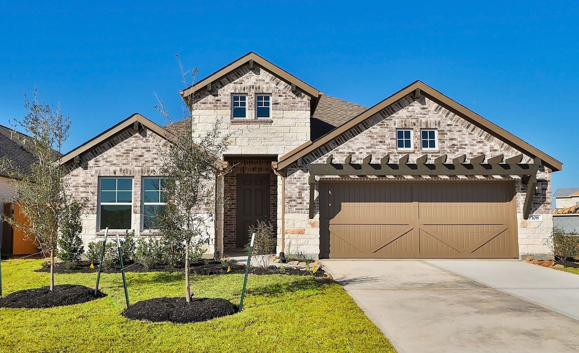 Modern Ranch Home with Pergola, River Ranch:Elegant brick and stone facade with a wooden pergola adds timeless appeal. Located in prestigious River Ranch.