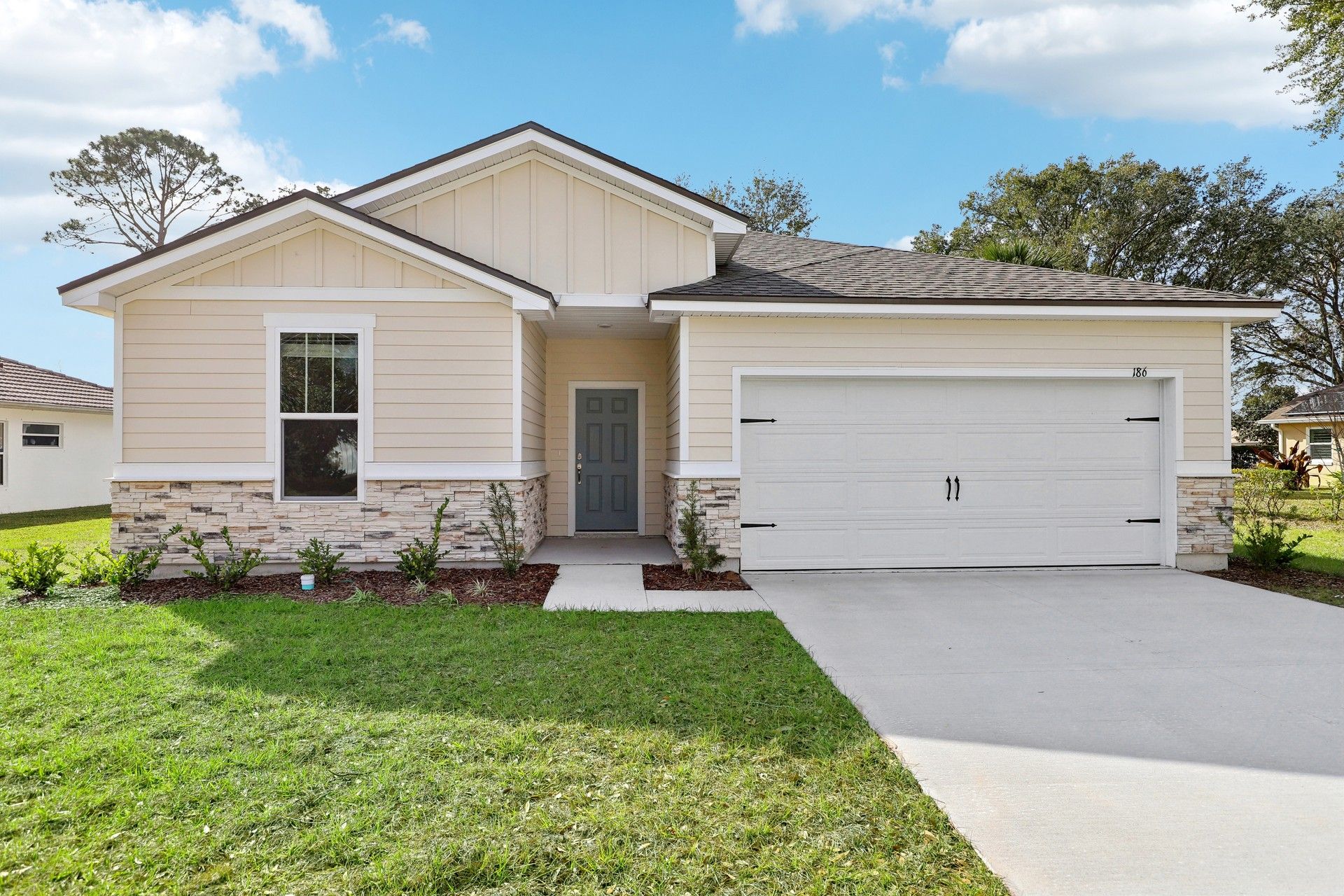 Palm Coast Modern Single-Story Home with Stone Accents:Elegant single-story design with stone facade, gabled roof. Designed for modern luxury in Palm Coast.